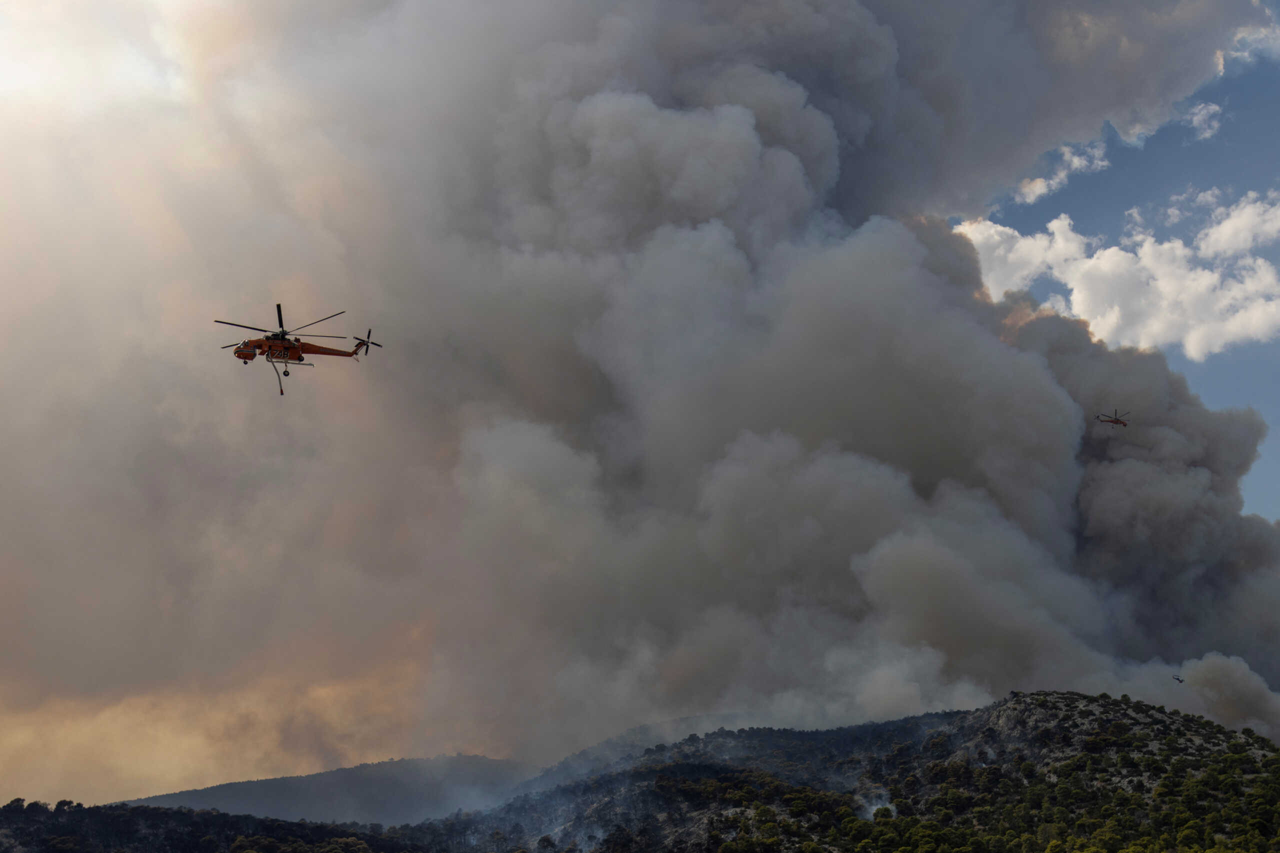 Firefighting helicopters operate, as a wildfire rages in Menidi, near Athens, Greece, August 23, 2023. REUTERS