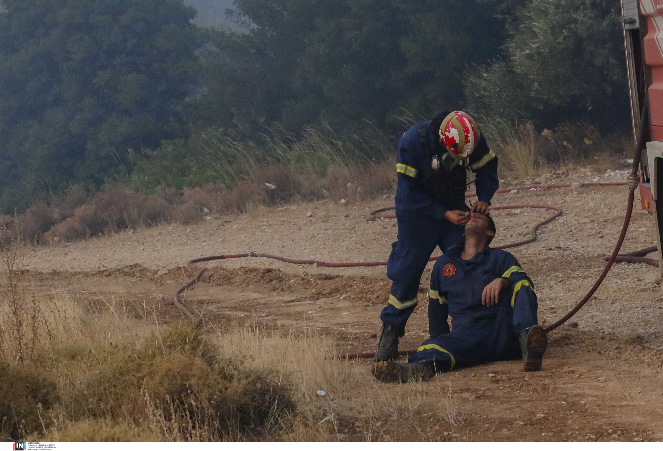 Φωτιά στην Πάρνηθα: Πυροσβέστης φροντίζει συνάδελφο στο πύρινο μέτωπο