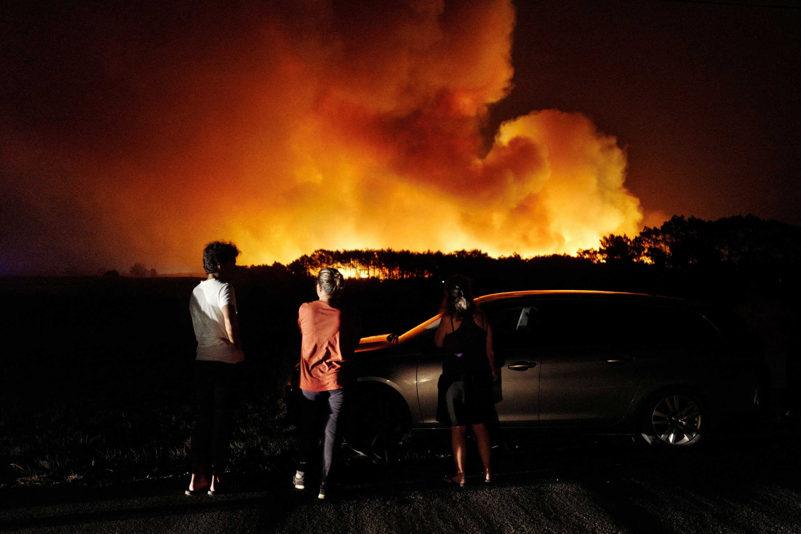 People watch a wildfire in Aljezur, Portugal, August 7, 2023. REUTERS