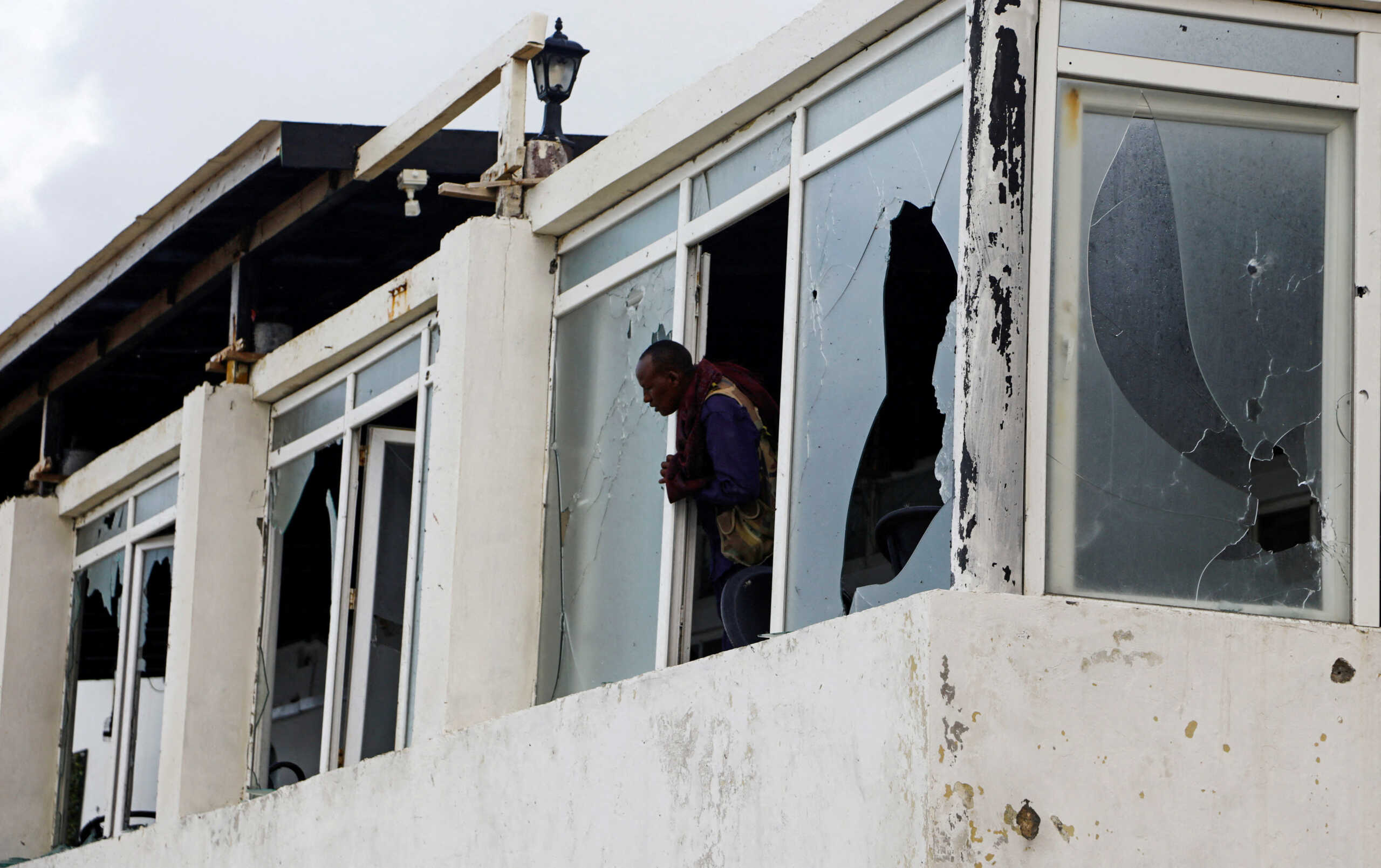 FILE PHOTO: A Somali police officer looks from the broken windows of the Pearl Beach Restaurant following an attack by Al Shabaab militants at the Liido beach in Mogadishu, Somalia June 10, 2023. REUTERS