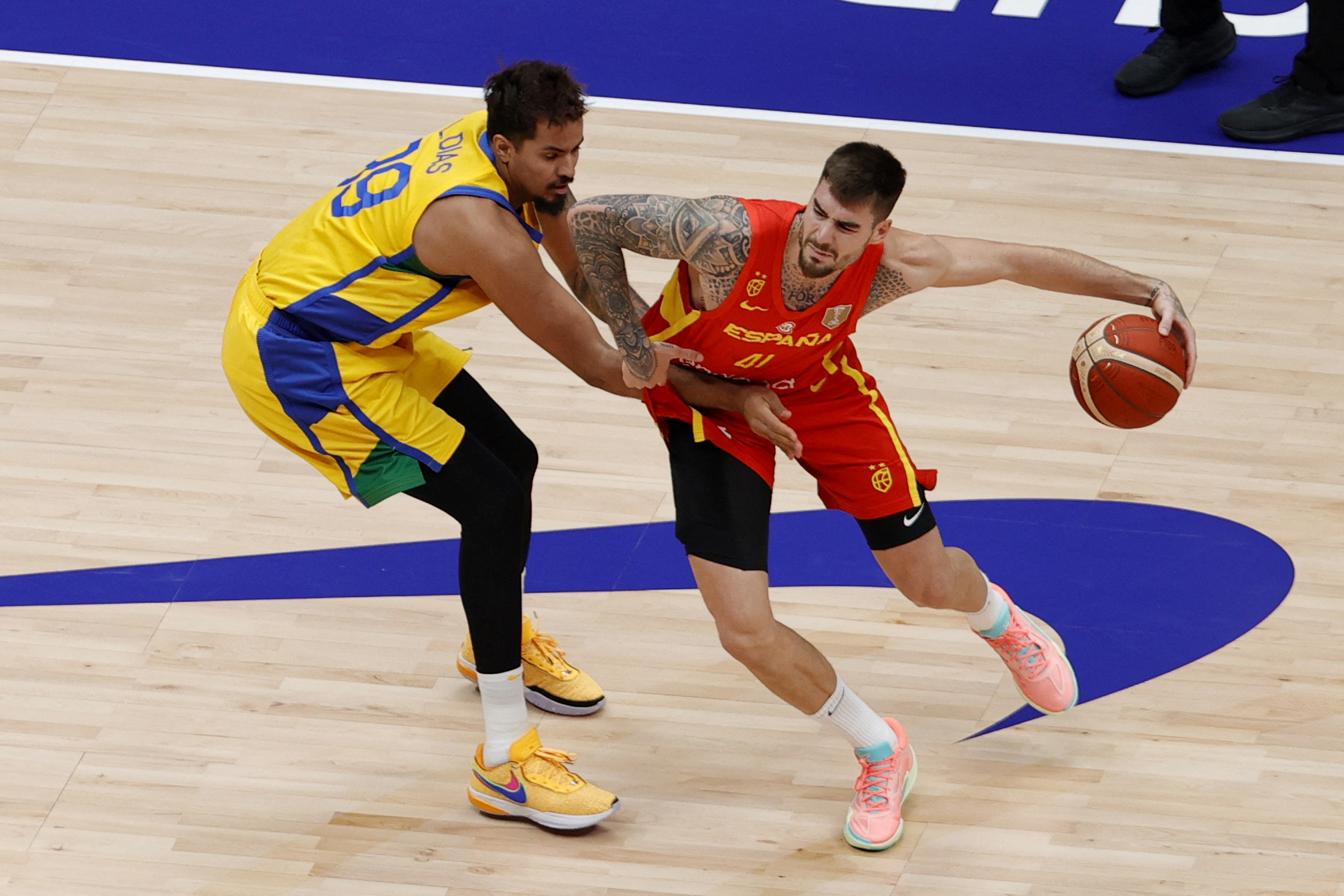 Basketball - FIBA World Cup 2023 - First Round - Group G - Brazil v Spain - Indonesia Arena, Jakarta, Indonesia - August 28, 2023 Brazil's Lucas Dias in action with Spain's Juancho Hernangomez REUTERS