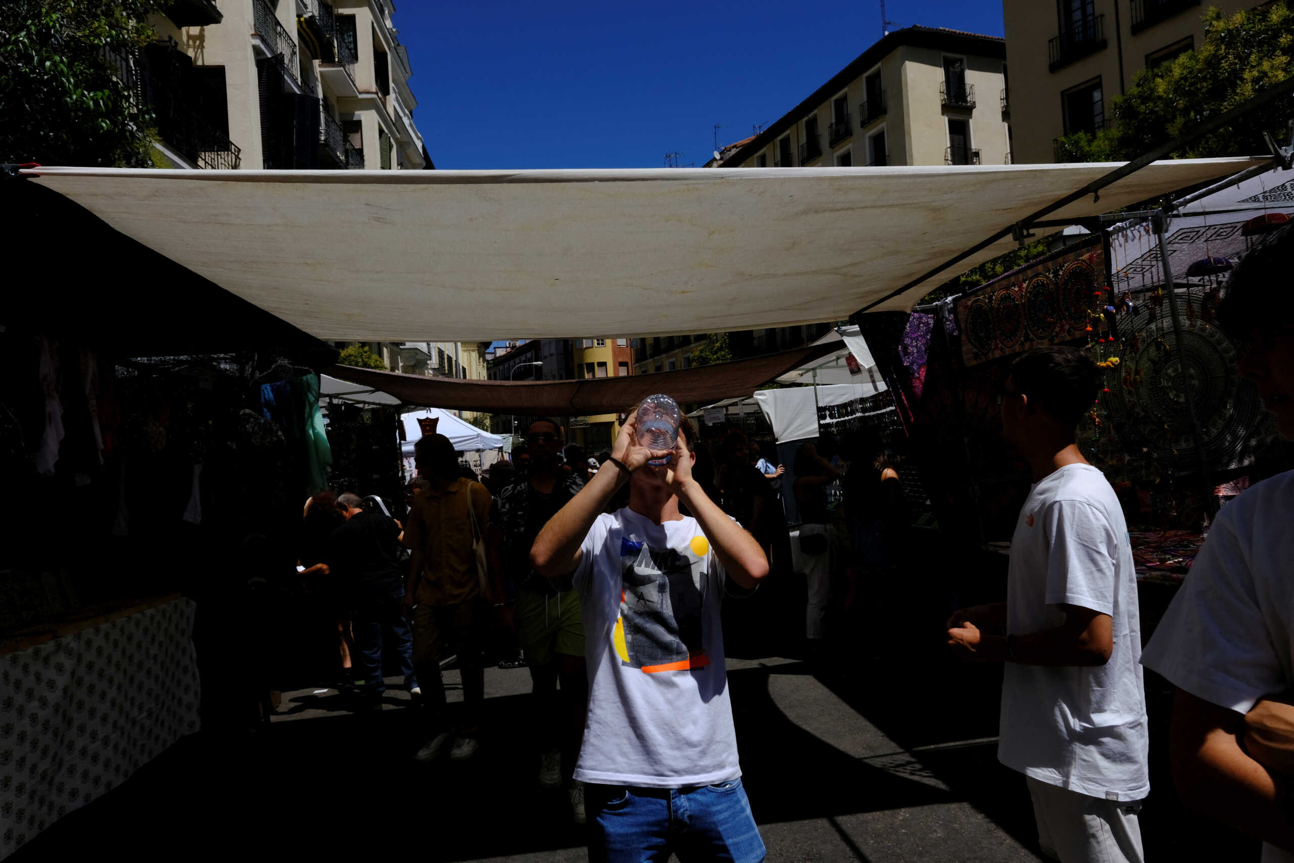 Ricardo Suarez, 15, drinks water as he visits the Rastro open-air market during a hot summer day in Madrid, Spain, August 6, 2023. REUTERS