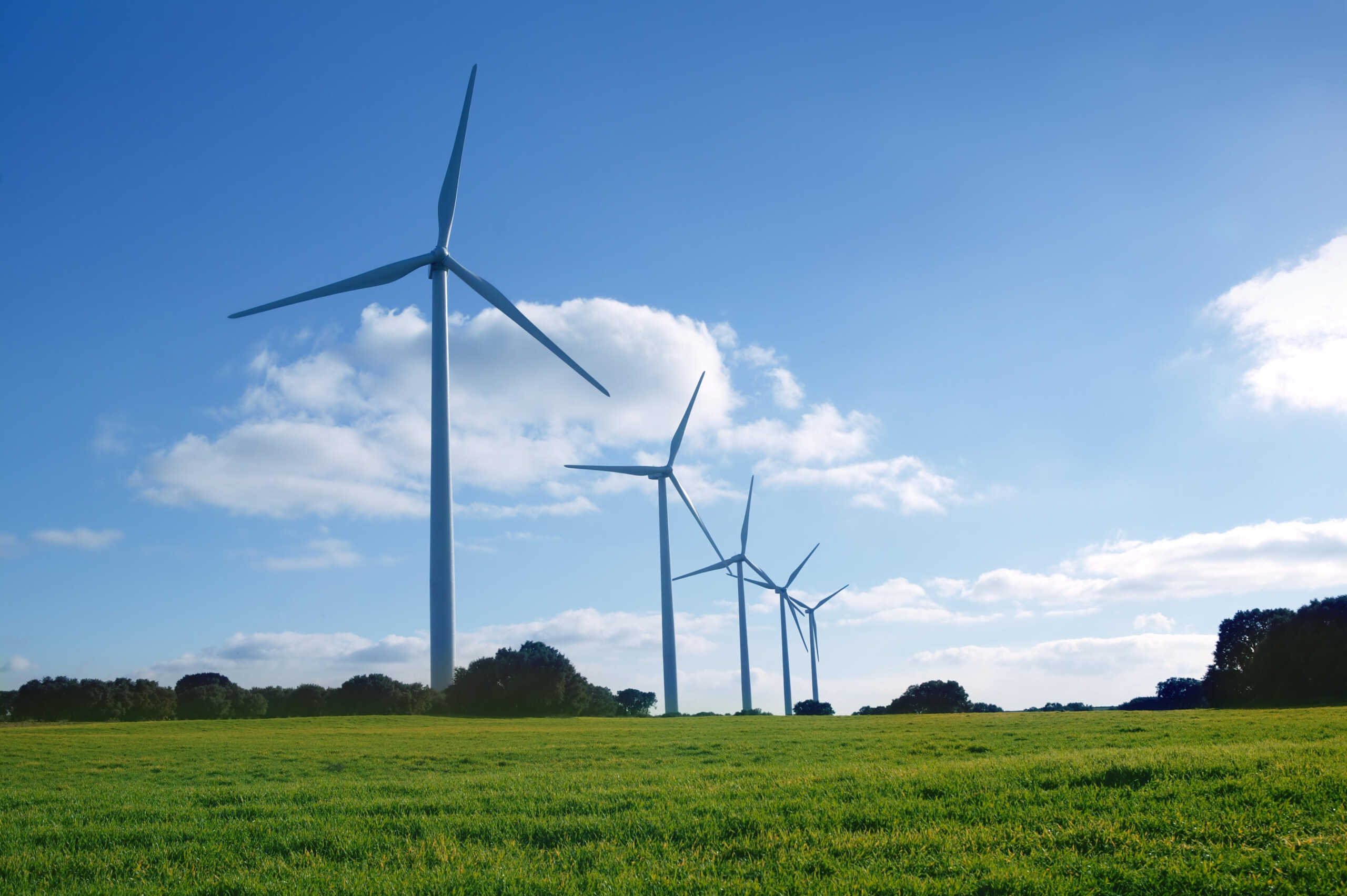 Ecological electric energy production by windmills in a meadow and blue sky