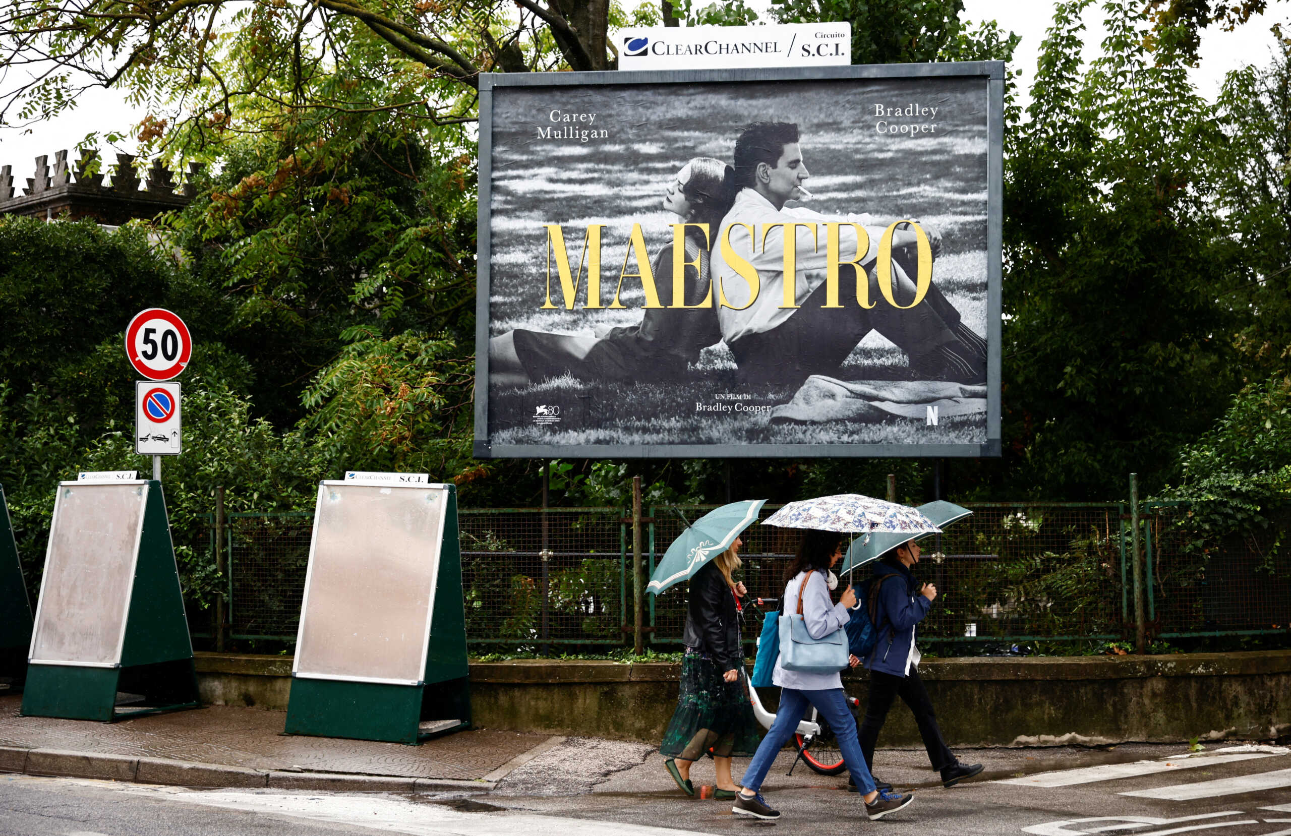 People walk past a poster for the film "Maestro" on the eve of the opening ceremony of 80th Venice Film Festival, in Venice, Italy, August 29, 2023. REUTERS