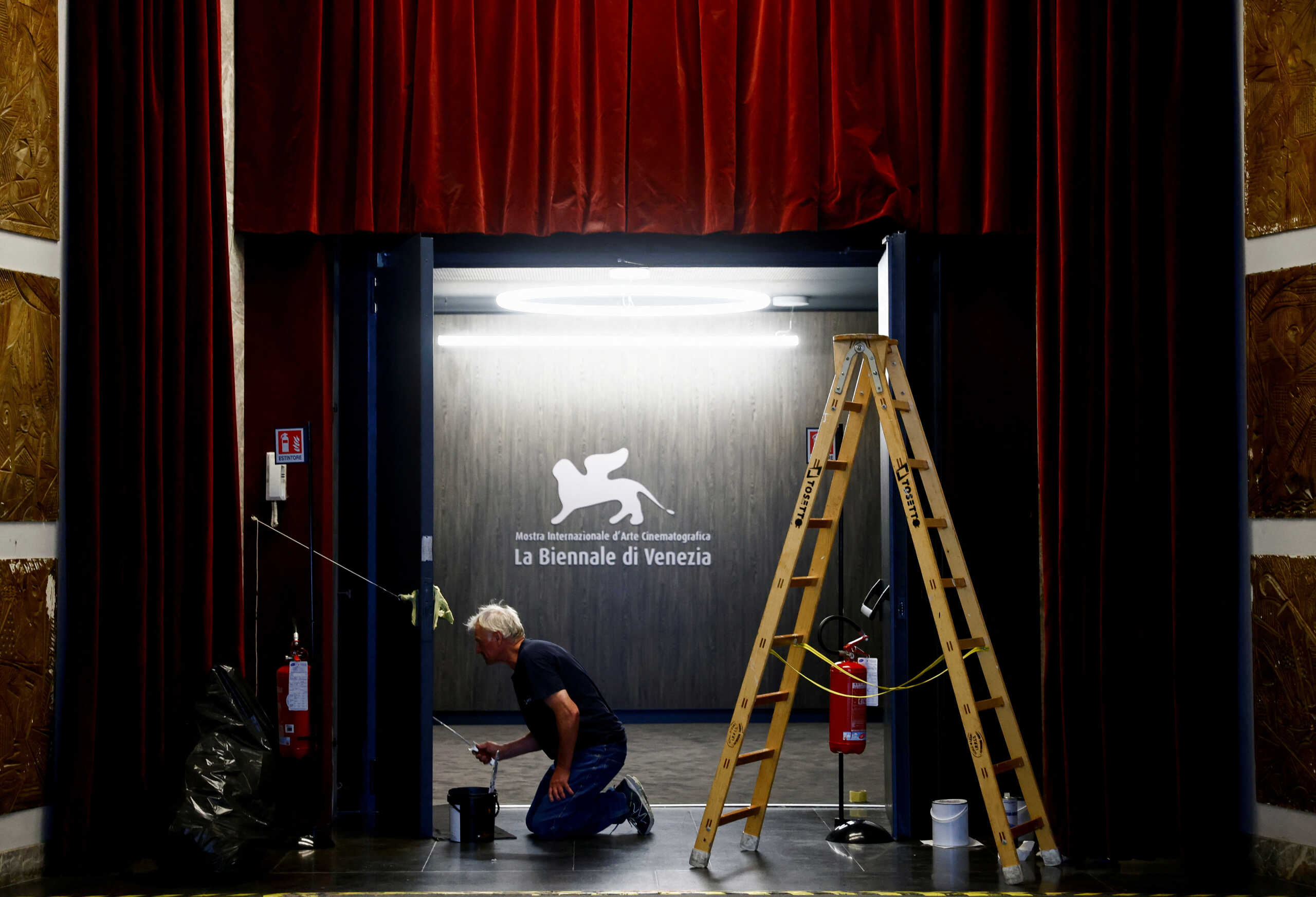 A worker paints a door in the Palazzo del Cinema, a day before the 80th Venice Film Festival starts in Venice, Italy August 29, 2023. REUTERS