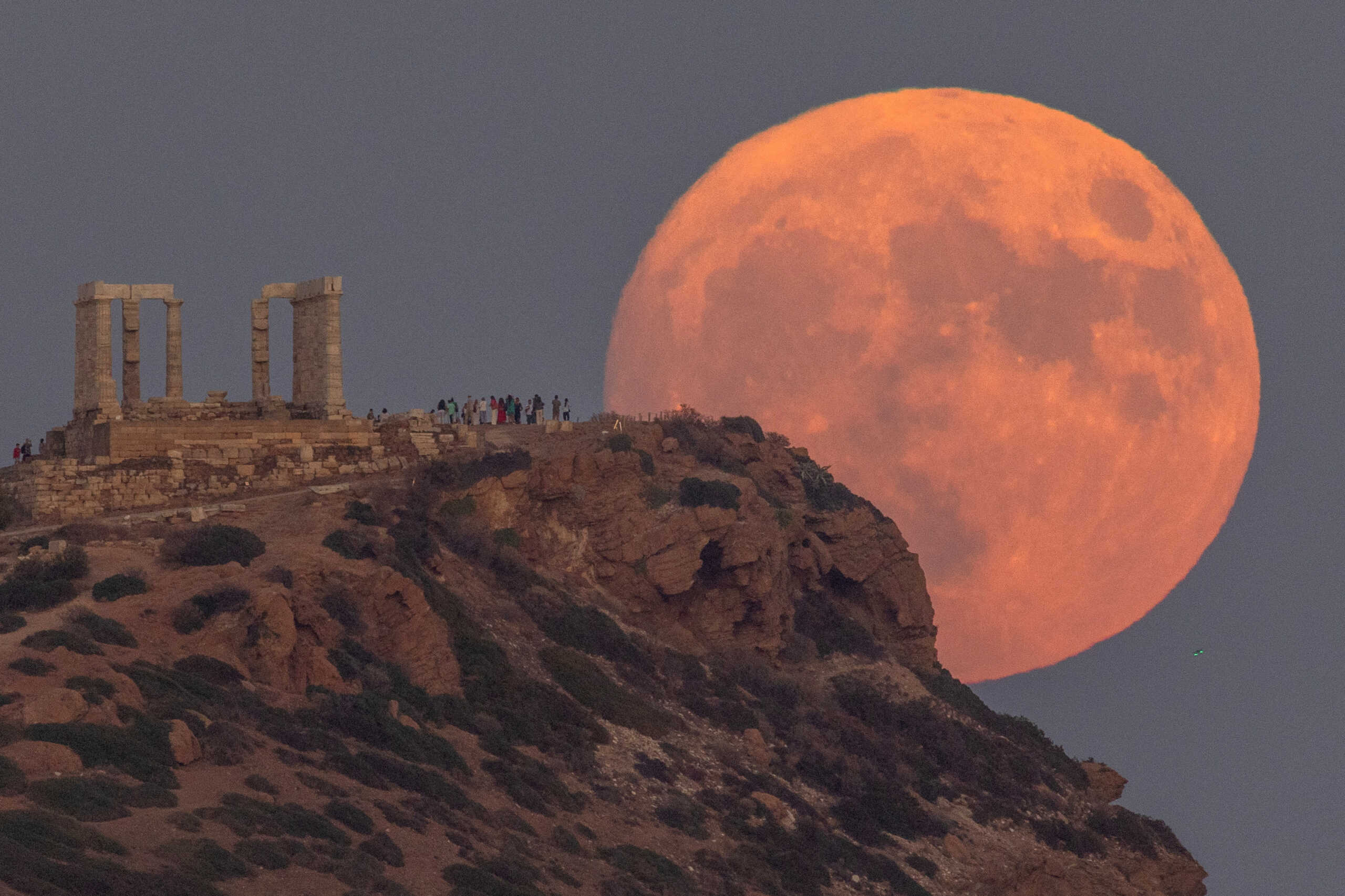 A full moon known as the "Blue Moon" rises behind the Temple of Poseidon, in Cape Sounion, near Athens, Greece, August 30, 2023. REUTERS