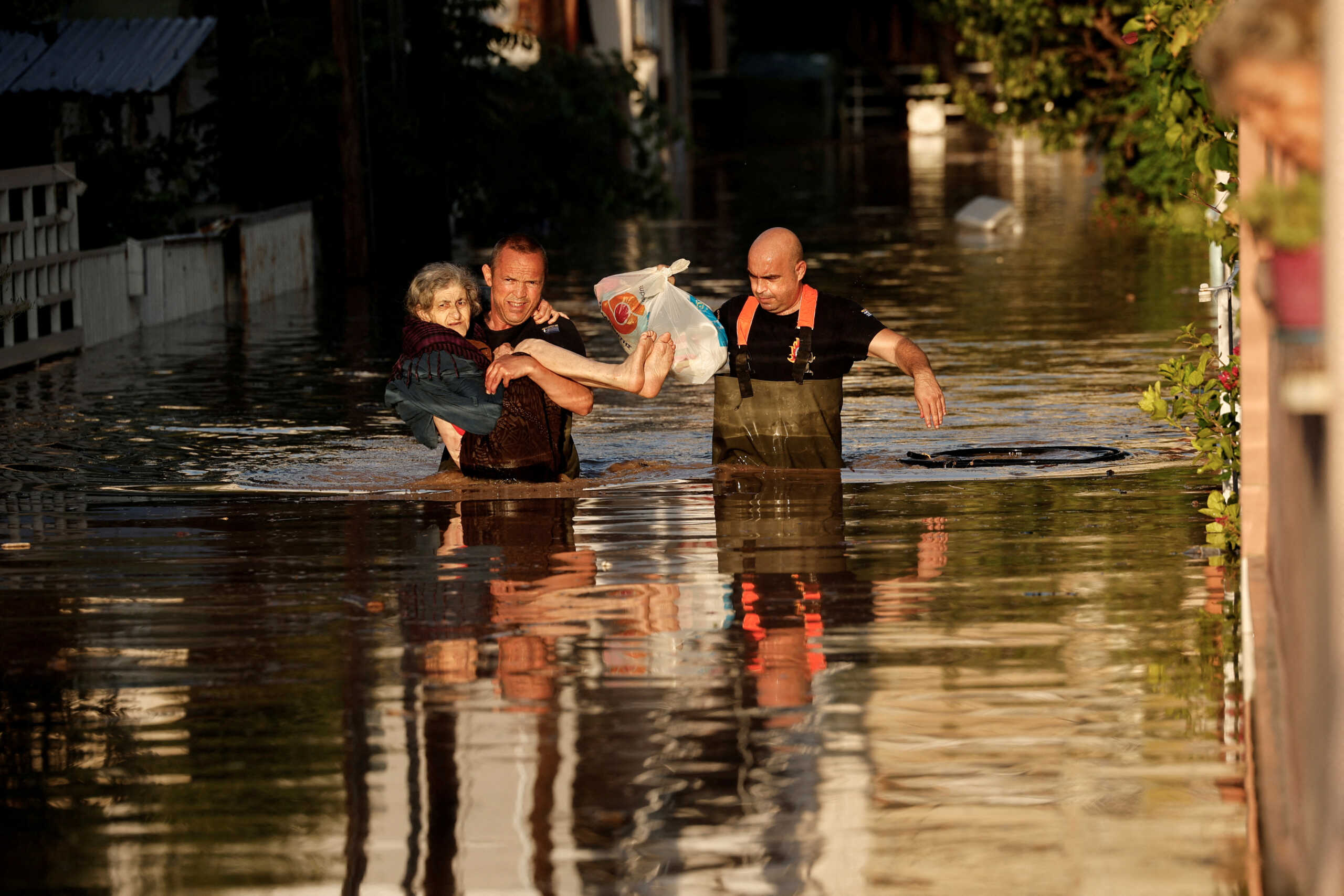 Firemen evacuate an elderly woman from her partially flooded house, as the Pinios river over flooded, after torrential rains in the area, in Larissa, Greece September 8, 2023. REUTERS