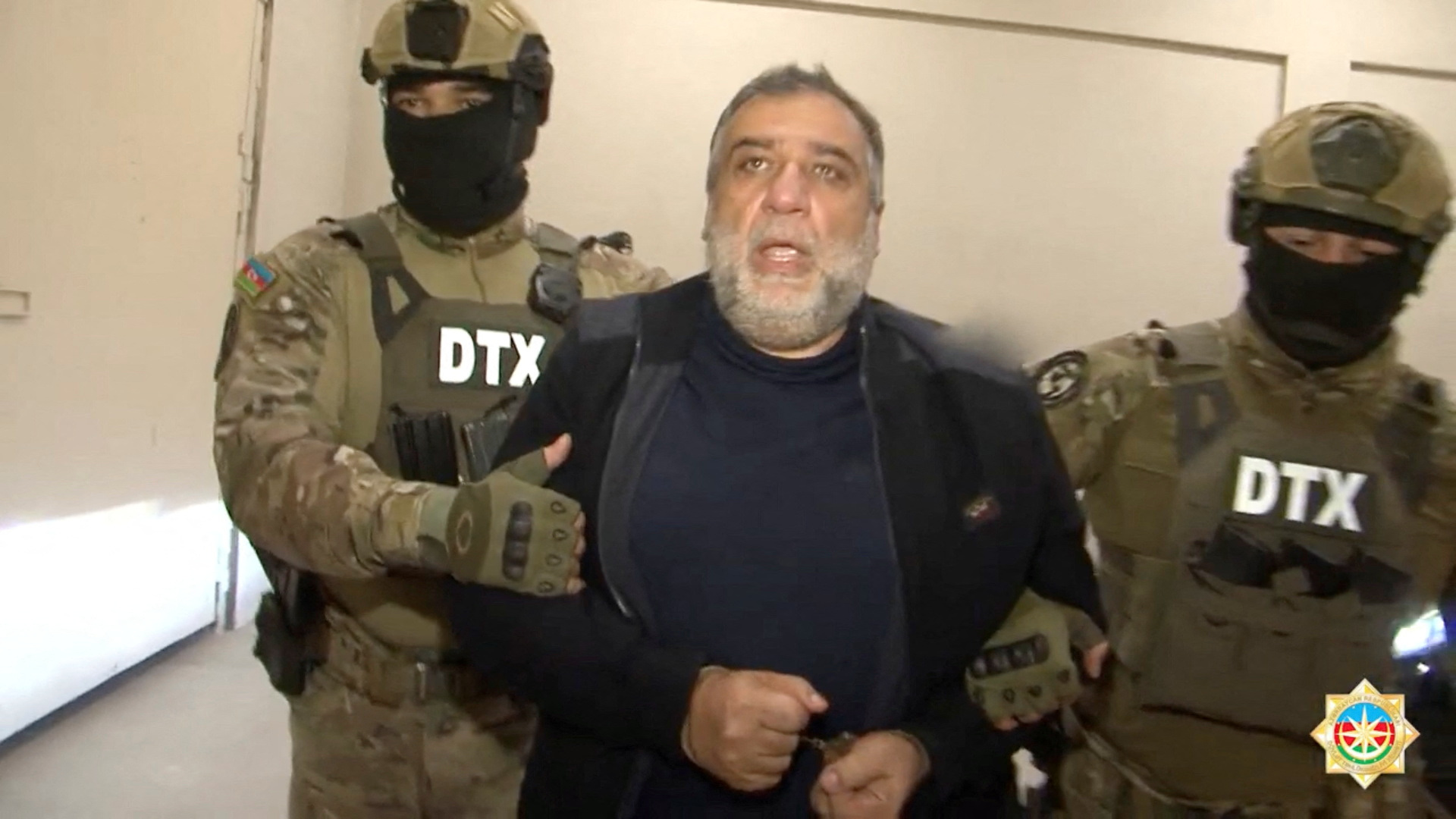 Law enforcement officers escort Ruben Vardanyan, the former head of government of the breakaway Nagorno-Karabakh region, after he was arrested by the Azerbaijani security service and accused of illegally crossing the Azerbaijani border and financing terrorism, at an unknown location in Azerbaijan, in this still image from video released September 28, 2023. State Security Service of Azerbaijan