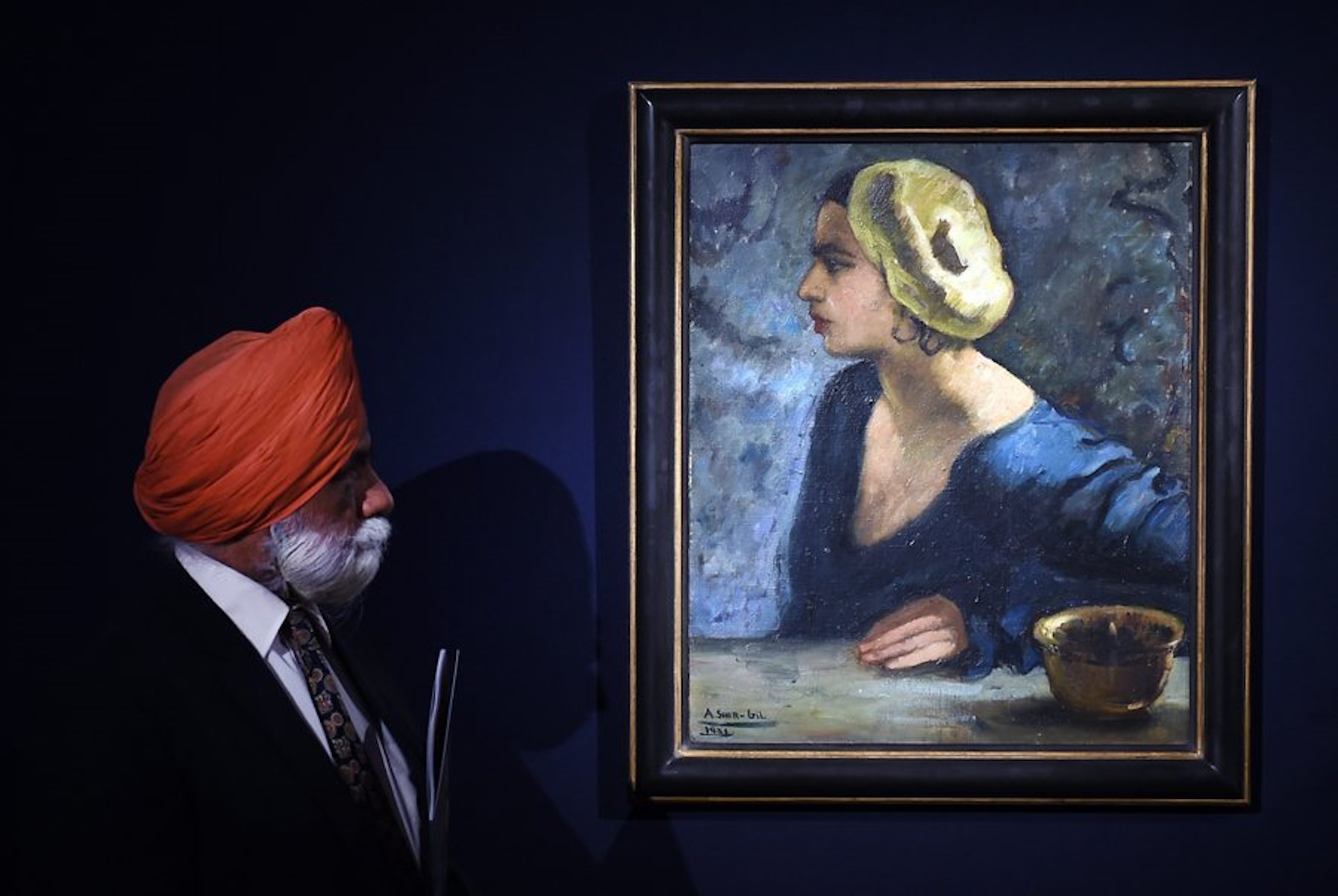 epa04783870 A man looks over Indian artist Amrita Sher-Gil's self portrait at Christie's auction house in London, Britain, 05 June 2015. The painting is expected to fetch 1.5 - 2 million euros at Christie's Indian and Modern Contemporary Art Sale on 25 June.  EPA