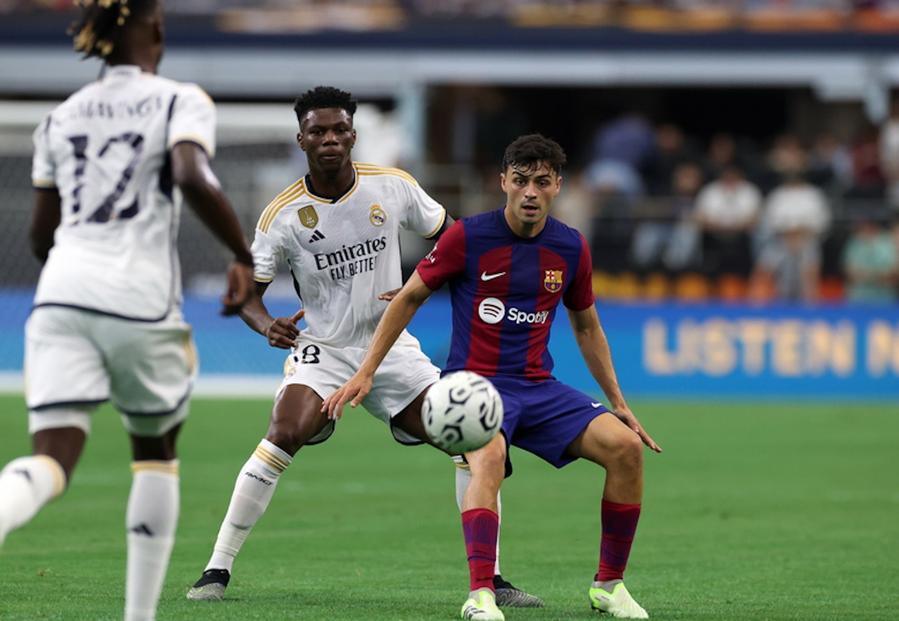 epa10776159 Real Madrid midfielder Aurelien Tchouamen (C) in action against FC Barcelona midfielder Pedri (R) during the friendly soccer match between FC Barcelona and Real Madrid, in Arlington, Texas, USA, 29 July 2023.  EPA