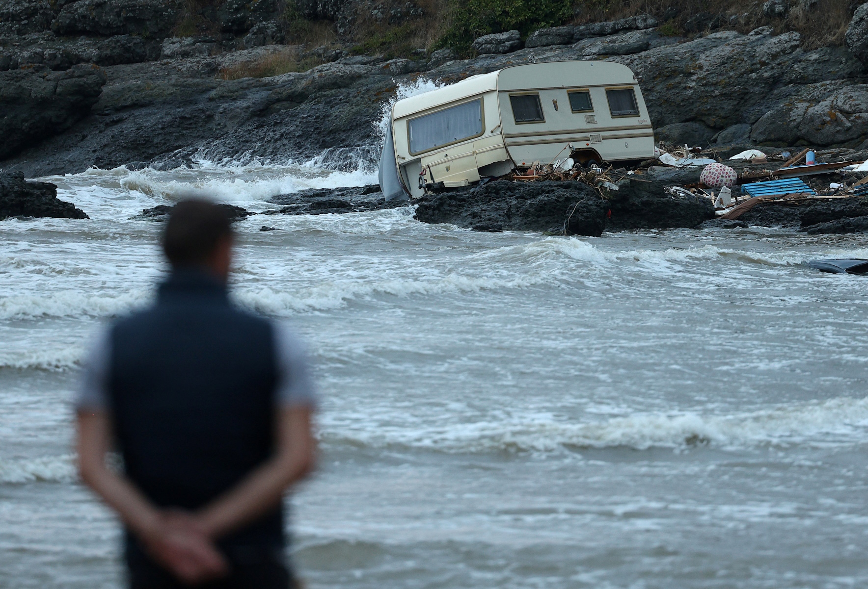 A man looks at a damaged camping trailer, washed away to the shore following severe flooding in Tsarevo, on the Black Sea coast, Bulgaria, September 6, 2023. REUTERS