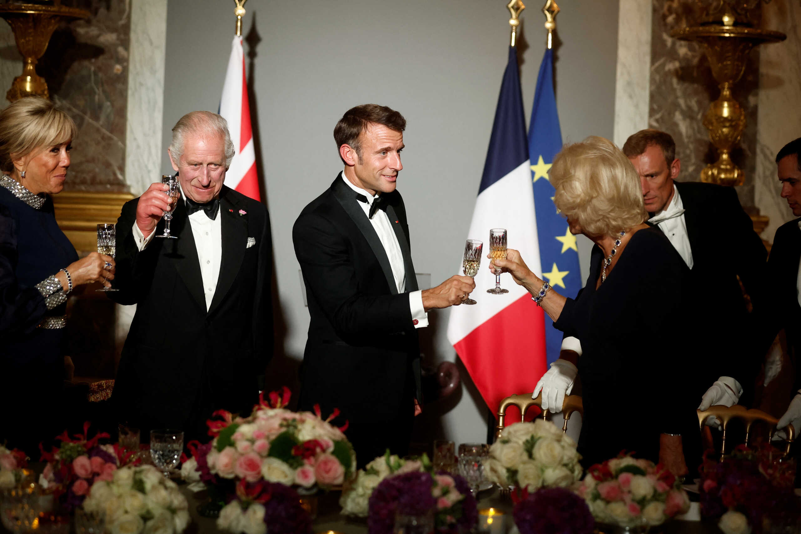 French President Emmanuel Macron, his wife Brigitte Macron, Britain's King Charles and Queen Camilla toast during a state dinner in the Hall of Mirrors (Galerie des Glaces) at the Chateau de Versailles (Versailles Palace) in Versailles, near Paris, on the first day of their State visit to France, September 20, 2023. REUTERS