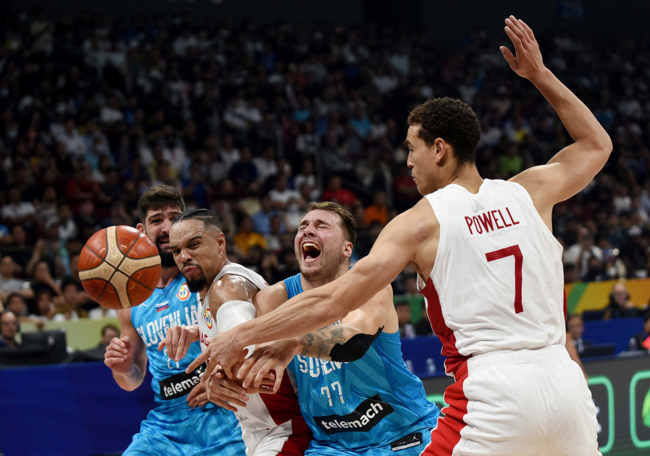 Basketball - FIBA World Cup 2023 - Quarter-Final - Canada v Slovenia - Mall of Asia Arena, Manila, Philippines - September 6, 2023 Slovenia's Luka Doncic in action with Canada's Dillon Brooks and Dwight Powell REUTERS