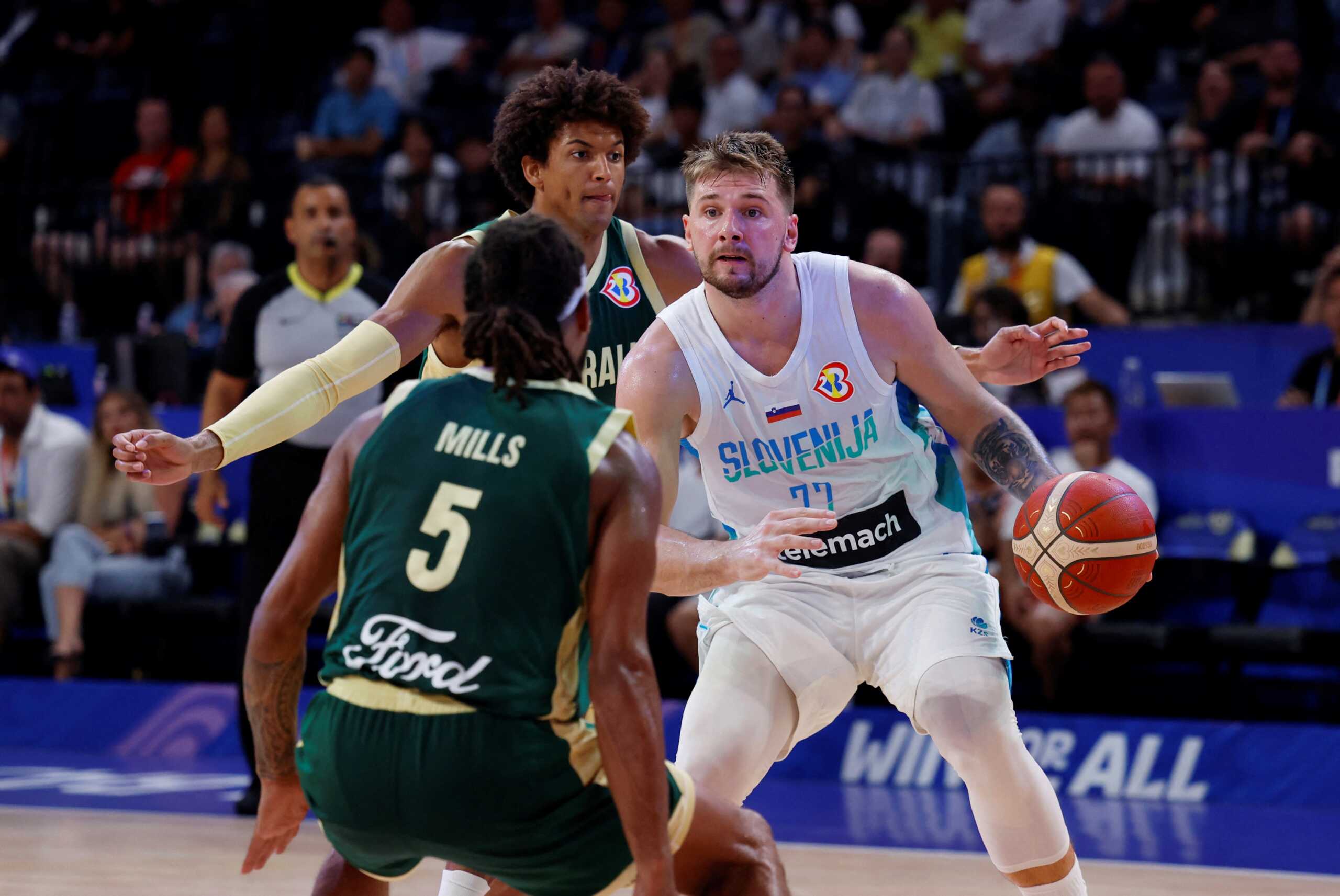 Basketball - FIBA World Cup 2023 - Second Round - Group K - Slovenia v Australia - Okinawa Arena, Okinawa, Japan - September 1, 2023 Slovenia's Luka Doncic in action with Australia's Matisse Thybulle and Patty Mills REUTERS