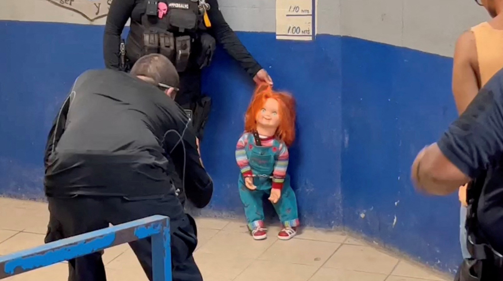A police officer holds the handcuffed "demon doll" Chucky by its hair after arresting Carlos "N", a man who used the doll with a knife to rob people, according to local media, in Monclova, Mexico, September 11, 2023, in this screen grab obtained from a handout video. Noticias NRT Mexico