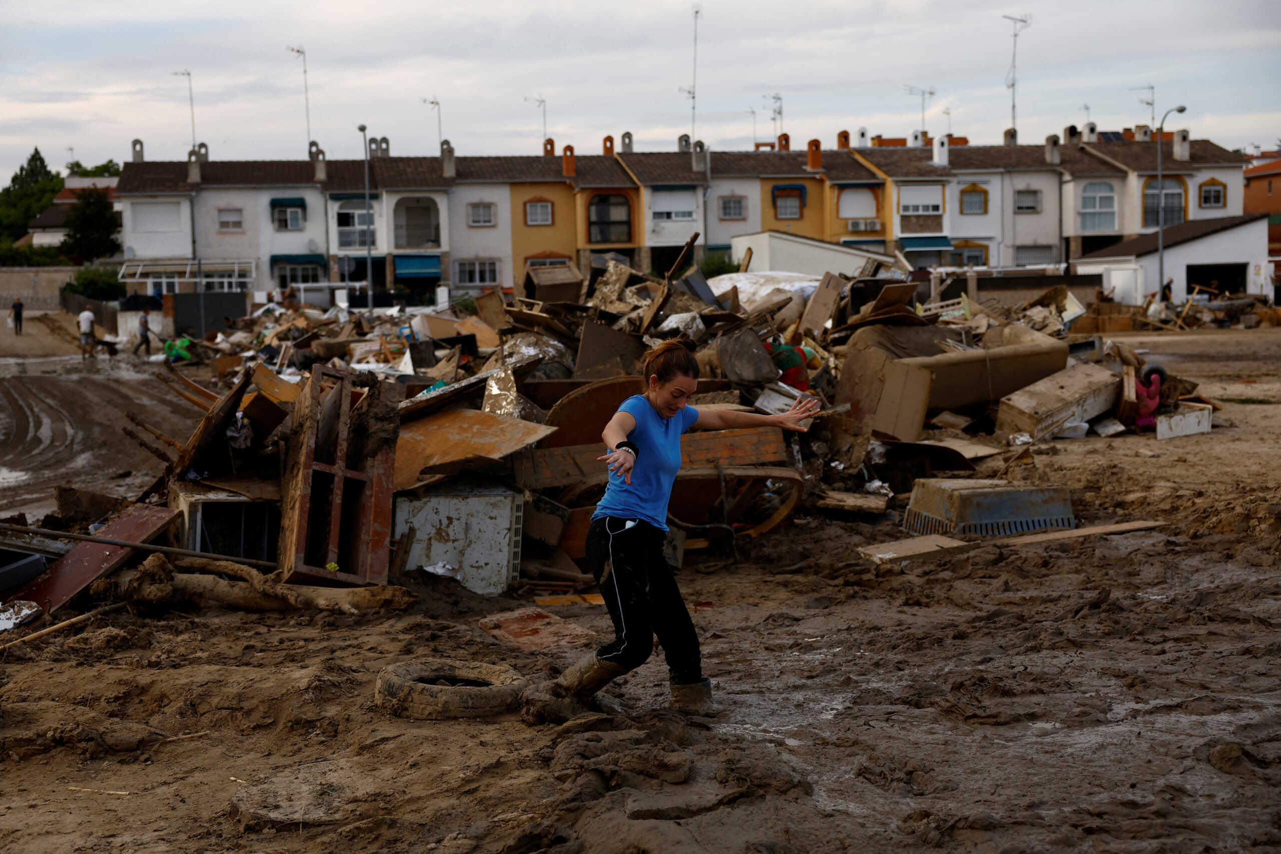Nuria Lozano, 28, gets stuck in the mud near her family's and neighbours' damaged belongings after heavy rains in Villamanta, Spain, September 6, 2023. REUTERS