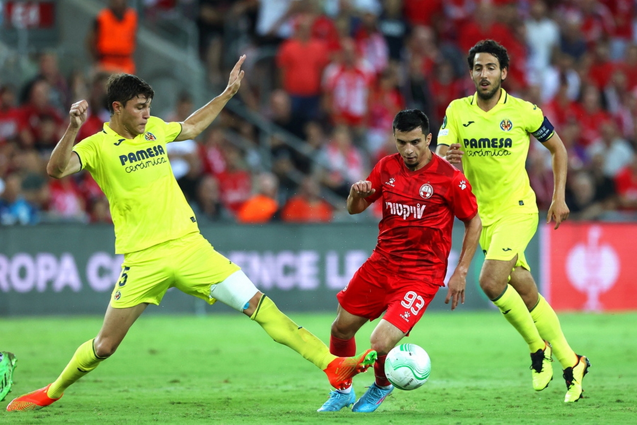 epa10186971 Cuenca Barreno (L) of Villarreal in action against Magomed Suleymanov (C) of Hapoel Beer-Sheva during the UEFA Europa Conference League group C soccer match between Hapoel Beer-Sheva and Villarreal CF in Beer Sheva, southern Israel, 15 September 2022.  EPA