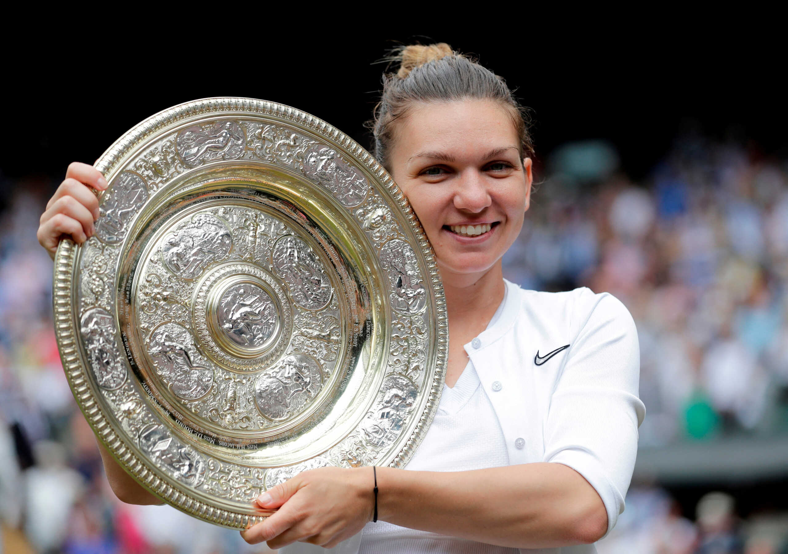 FILE PHOTO: Tennis - Wimbledon - All England Lawn Tennis and Croquet Club, London, Britain - July 13, 2019  Romania's Simona Halep poses with the trophy as she celebrates after winning the final against Serena Williams of the U.S.  Ben Curtis
