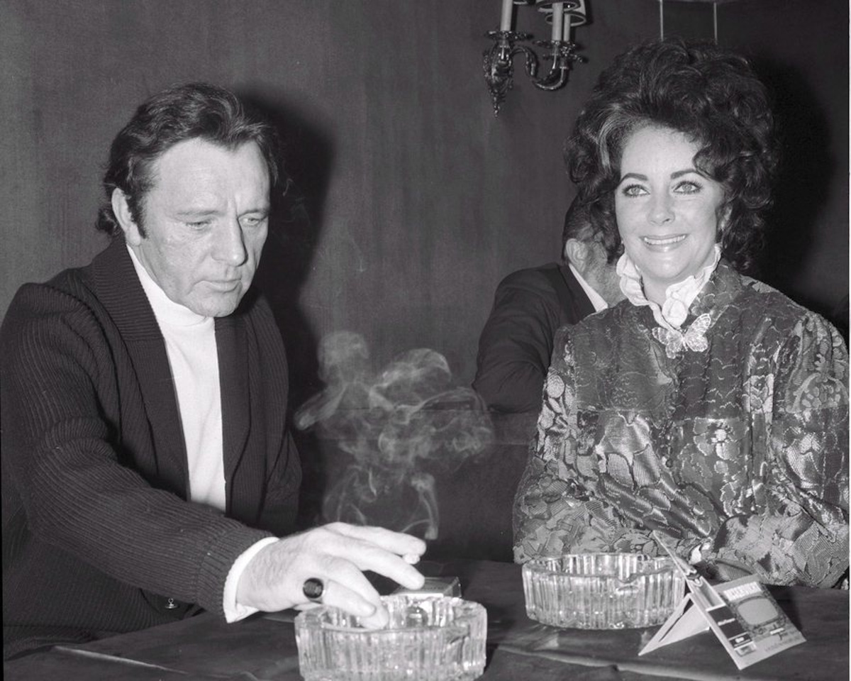 epa02649159 A black and white picture dated 10 February 1972 shows US-British actress Elizabeth Taylor (R) with her husband British actor Richard Burton during a cocktail party at Moulin Rouge night club in Budapest, Hungary during the first day of the shooting of their film 'Bluebeard'. According to media reports on 23 March 2011, Taylor died of congestive heart failure at the age of 79 at Cedars-Sinai Hospital in Los Angeles, USA.  EPA