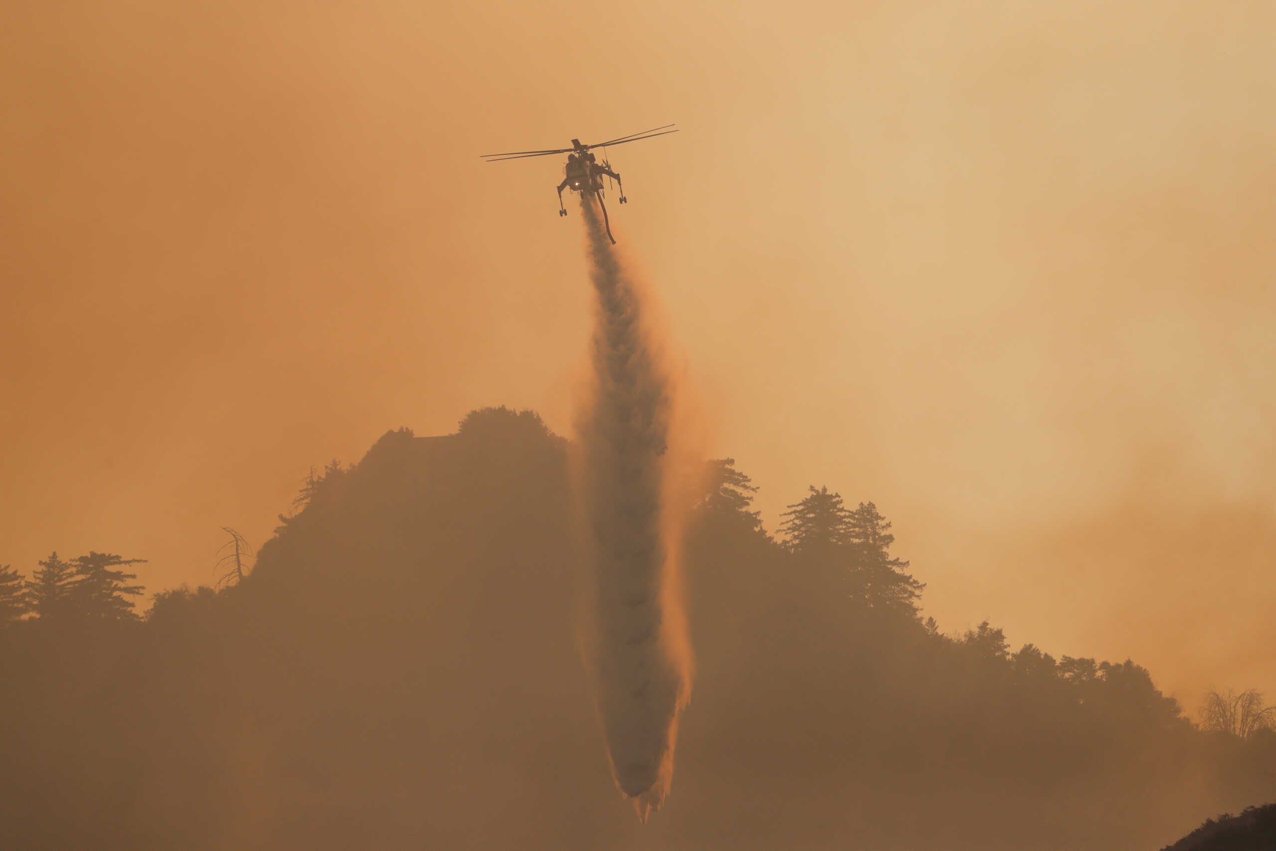 FILE PHOTO: A helicopter makes a water drop over the Bobcat Fire burning near Mount Wilson in the Angeles National Forest, near Los Angeles, U.S., September 23, 2020. REUTERS