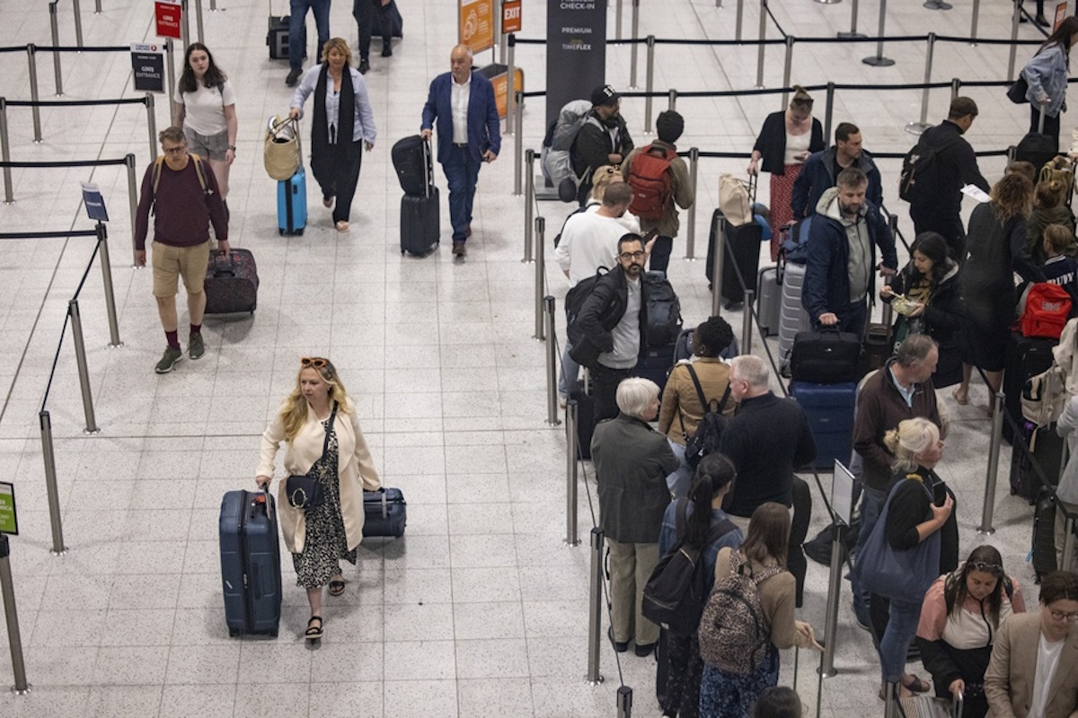 epa09987809 Travellers queue to check in for their flights at Gatwick Airport in London, Britain, 31 May 2022. Holidaymakers across the UK face continuing travel disruptions due to flight cancellations and lack of airport and airline staff during the first school holidays in England and Wales since the lifting of all UK Covid-19 travel restrictions.  EPA