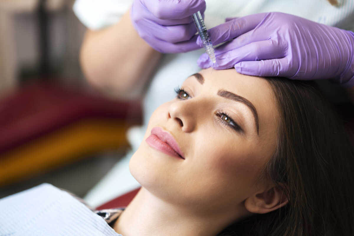 Young woman on a beauty treatment with the filler injection at the beauty clinic.