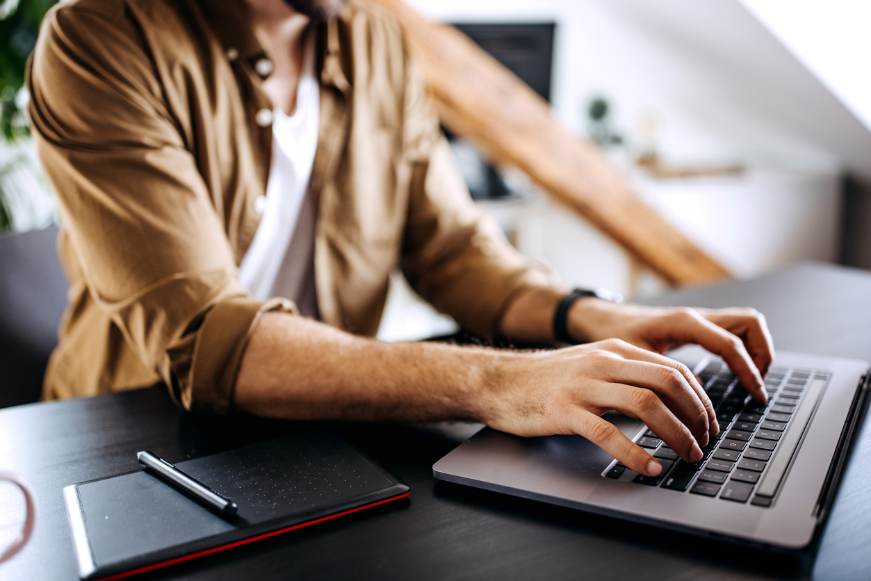 Young casually clothed man using laptop
