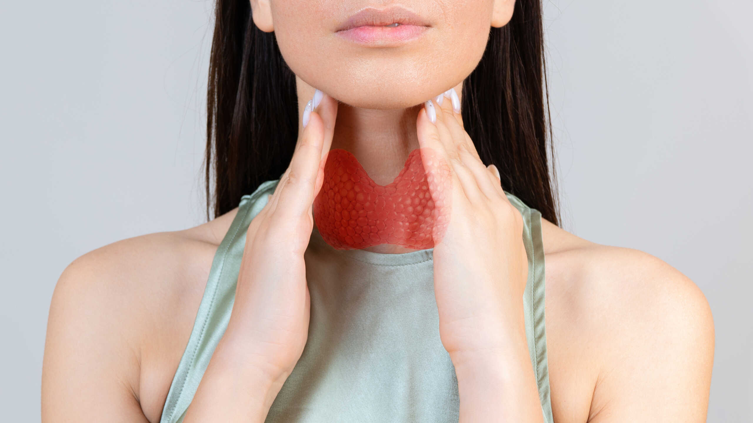 Sore throat in flu season. Young asian woman touching her neck and feeling pain in throat in the bedroom at home.
