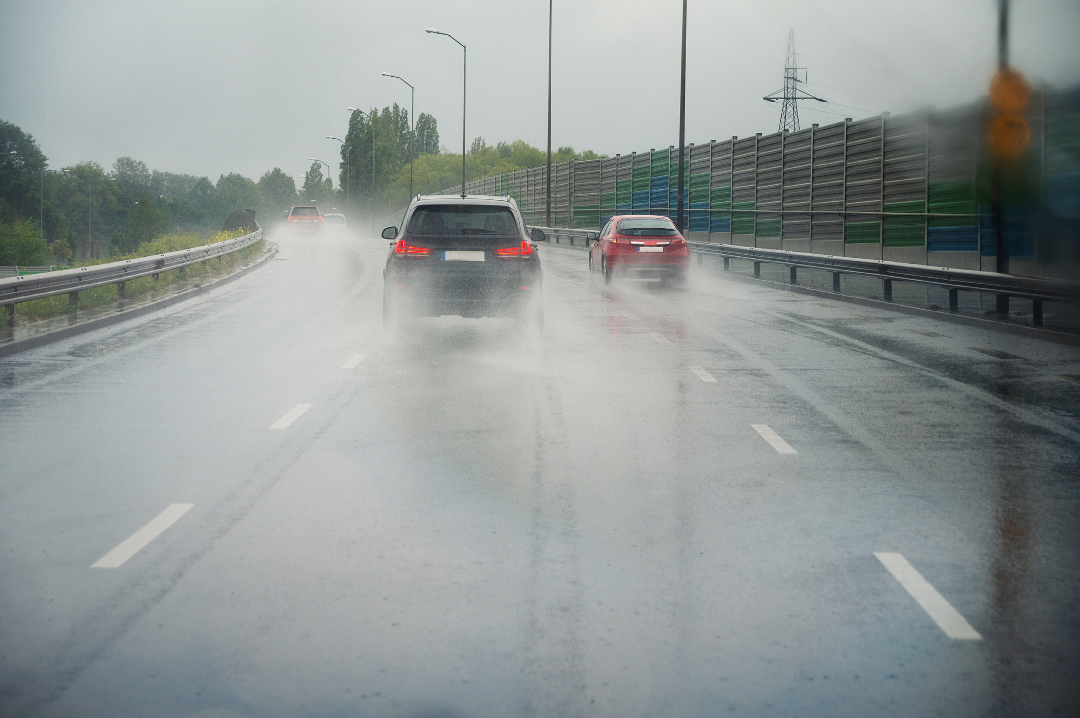 Cars driving on the road, heavy rain, low visibility, slippery street, dangerous storm, overcast weather