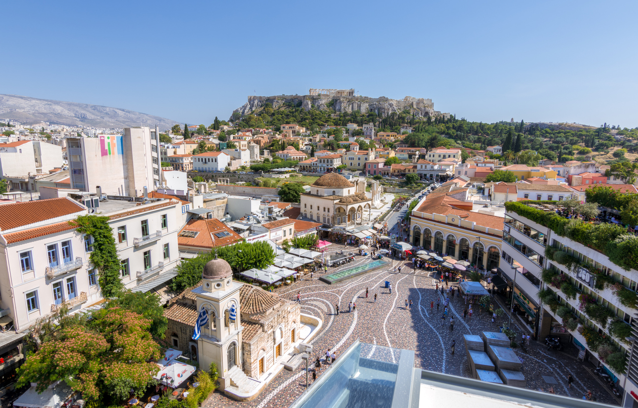 Athens, Greece - June 14, 2017. People visiting Monastiraki square as seen from a high point of view. Akropolis and Plaka in the background