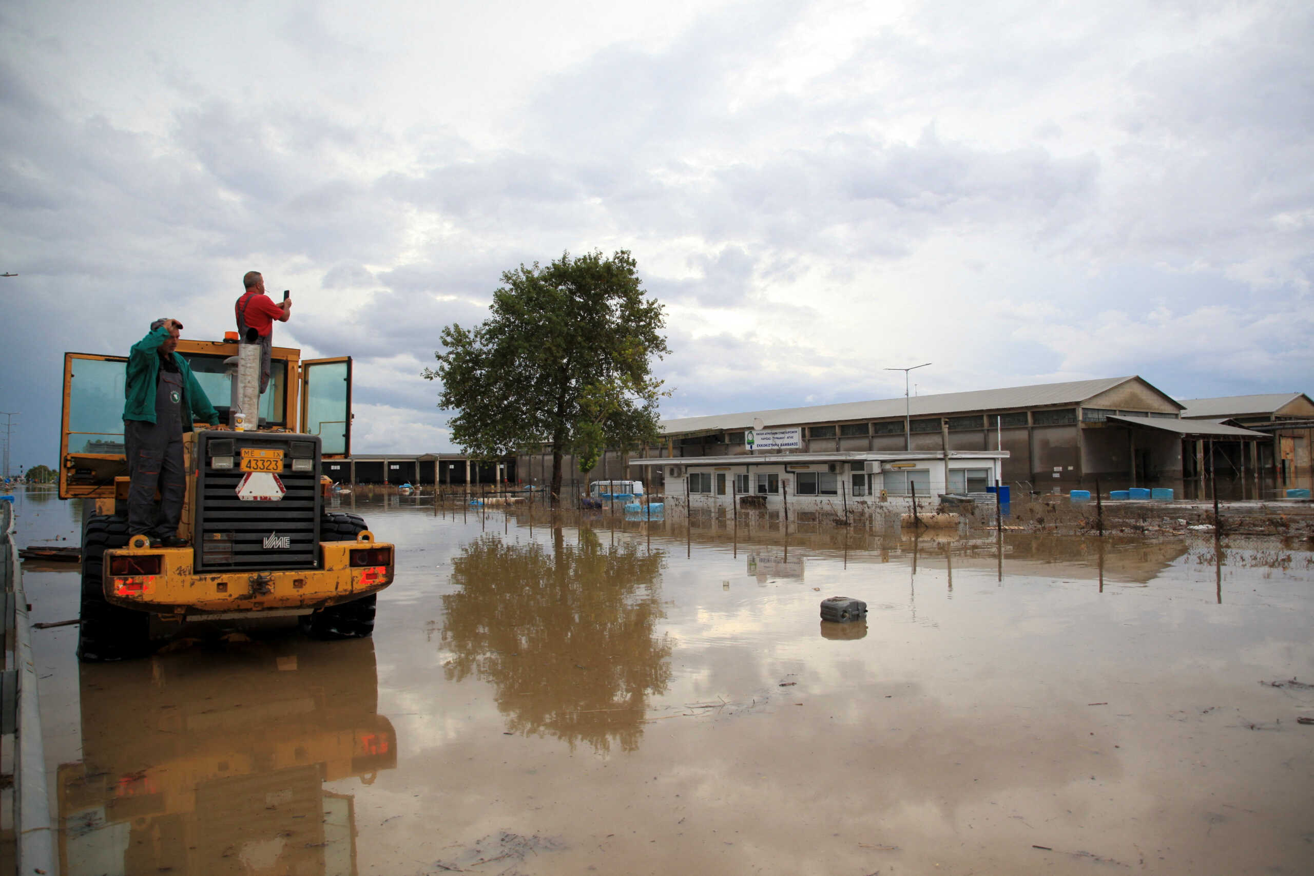 A local takes photos of flood waters covering the industrial area of Larissa, as storm Daniel hits central Greece, in Larissa, Greece, September 7, 2023. REUTERS