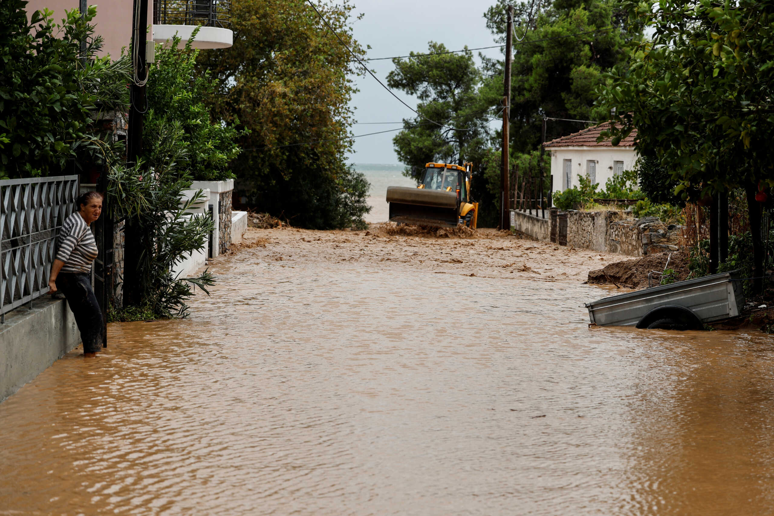 A woman stands in floodwater by her house after torrential rains destroyed the infrastructure and caused flooding in the area, in Agria, Pelion, central Greece  September 6, 2023.  REUTERS