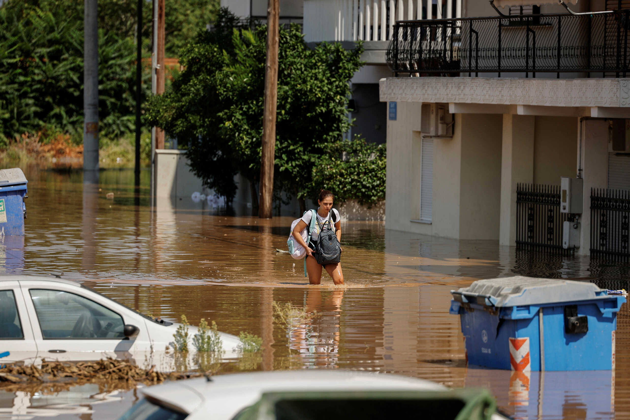 A woman walks away from a flooded area while carrying her belongings, in the aftermath of Storm Daniel in central Greece, in Larissa, Greece, September 8, 2023. REUTERS