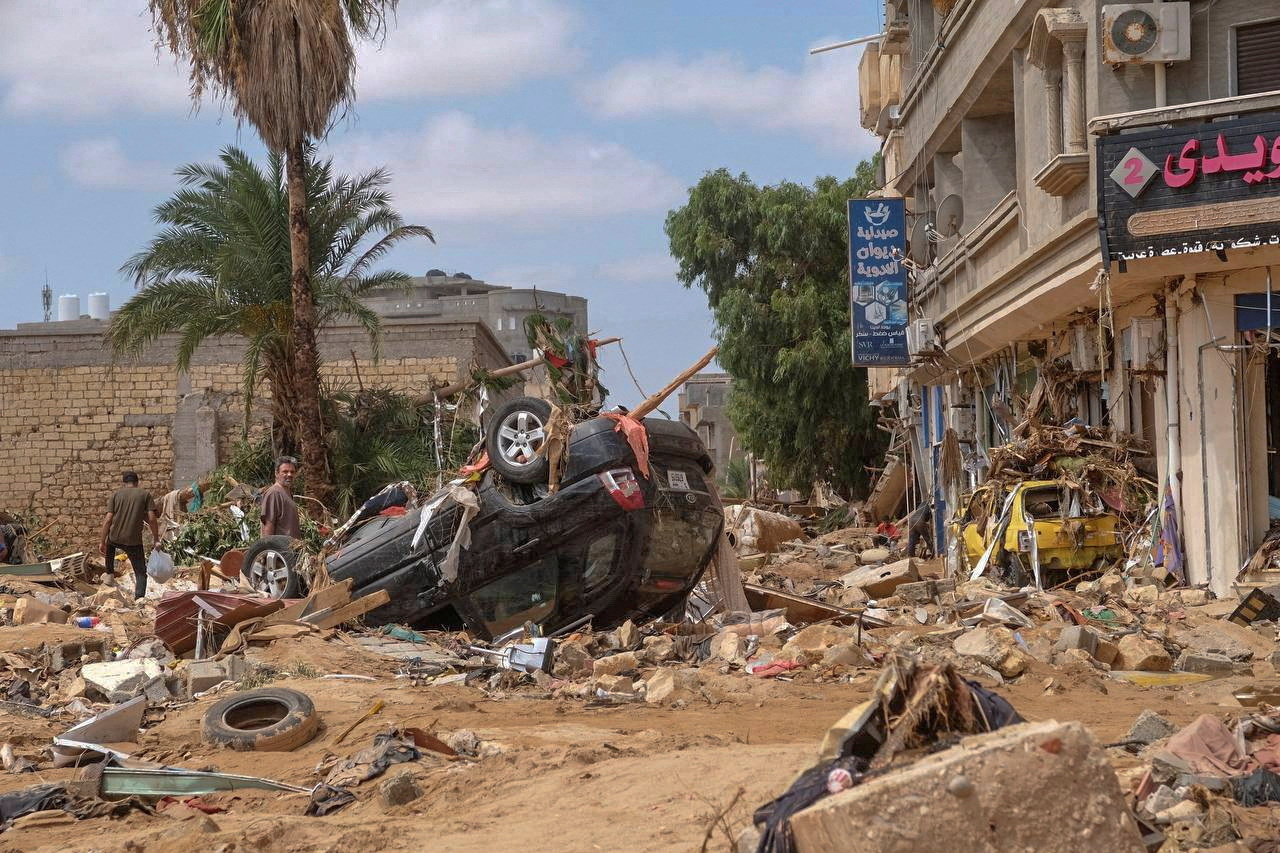 A man stands next to a damaged car, after a powerful storm and heavy rainfall hit Libya, in Derna, Libya September 12, 2023. REUTERS