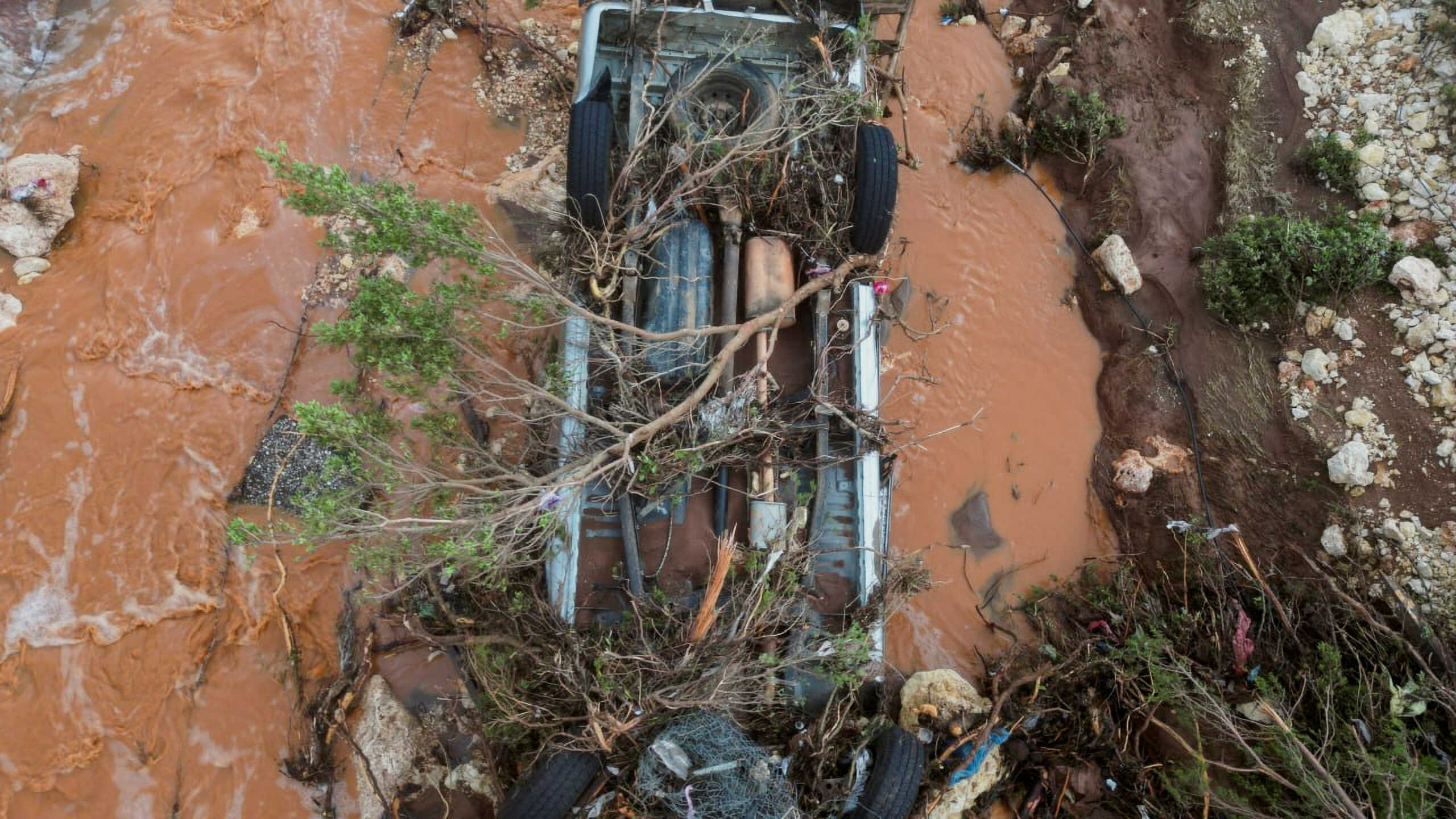 Aerial view of a damaged car and flood water on a road as a powerful storm and heavy rainfall hit Shahhat city, Libya, September 11, 2023. REUTERS