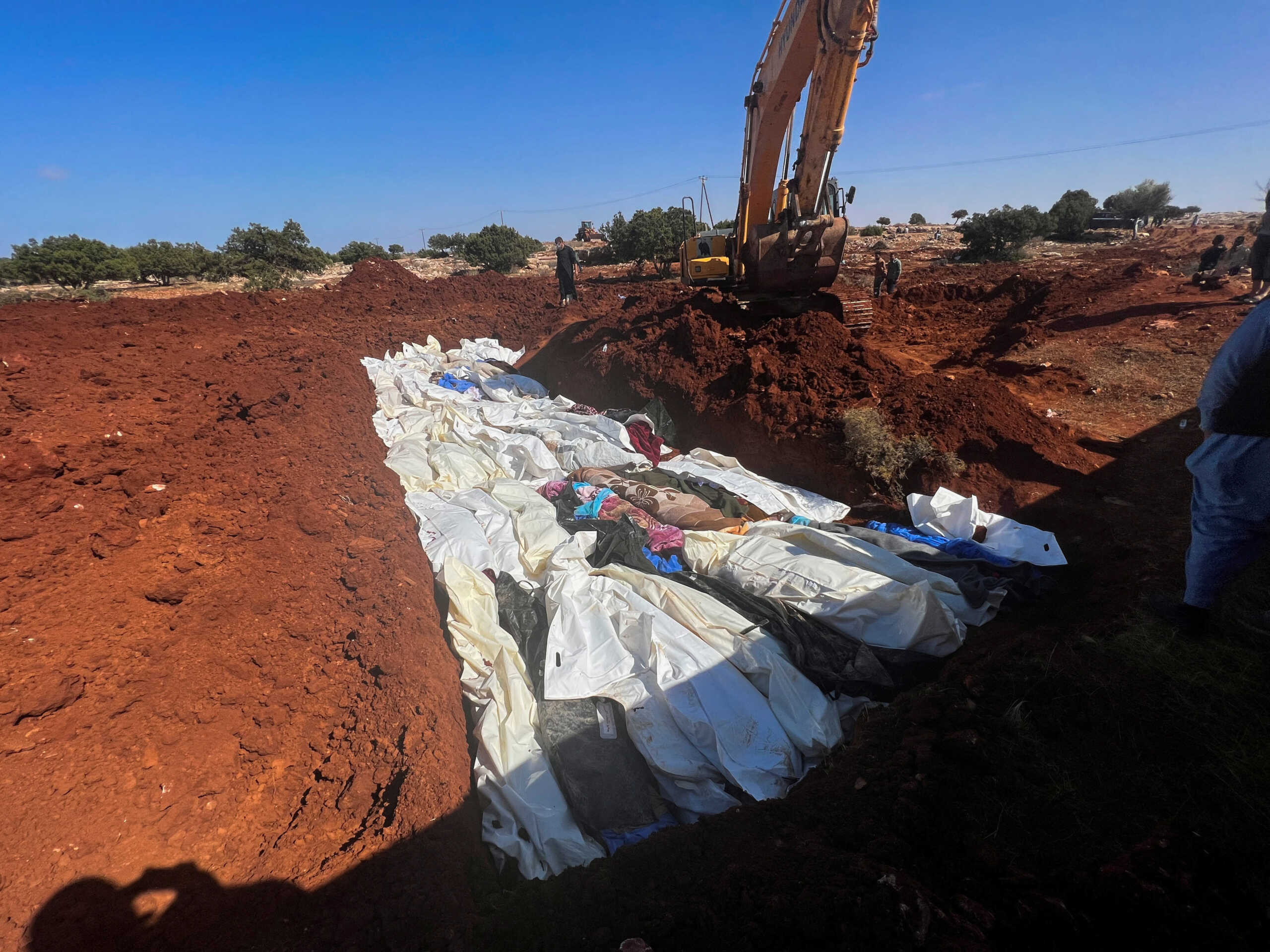 Bodies of victims are placed at a mass grave after a powerful storm and heavy rainfall hit Libya, in Derna, Libya September 12, 2023. REUTERS