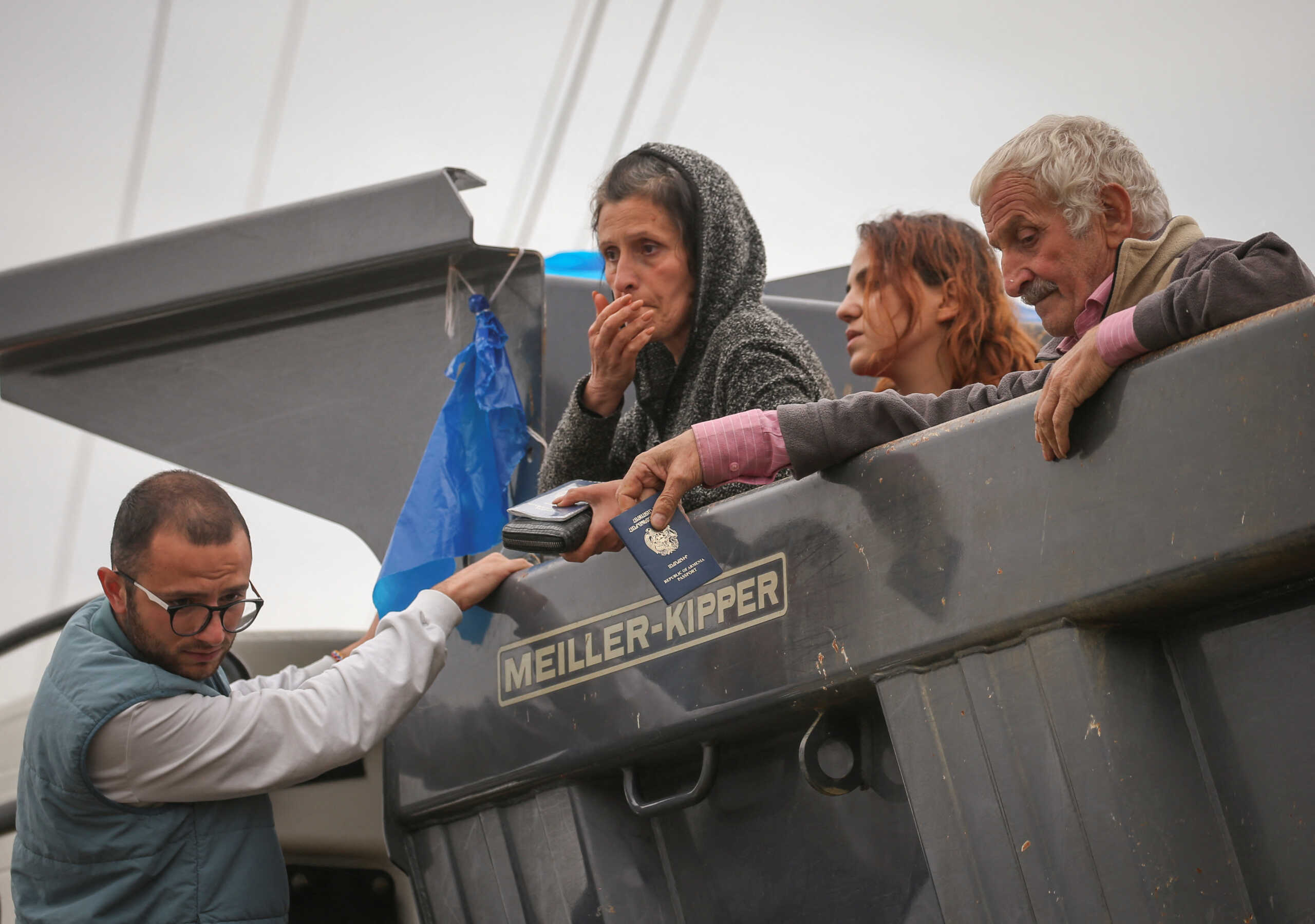 Refugees from Nagorno-Karabakh region sit in the back of a truck upon arrival in the border village of Kornidzor, Armenia, September 26, 2023. REUTERS