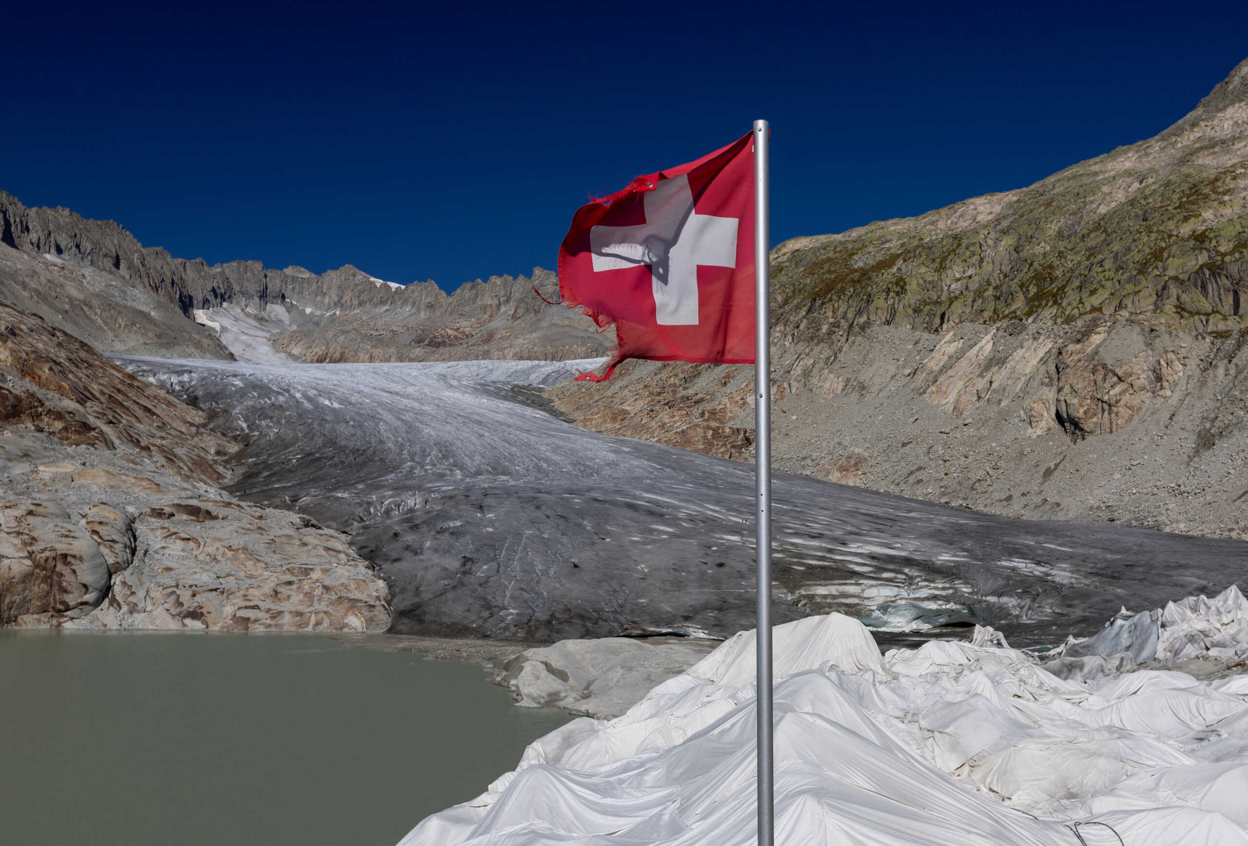 A Swiss flag is seen at the entrance of the ice cave on the Rhone glacier, amid climate change, in Obergoms, Switzerland, September 26, 2023.  REUTERS