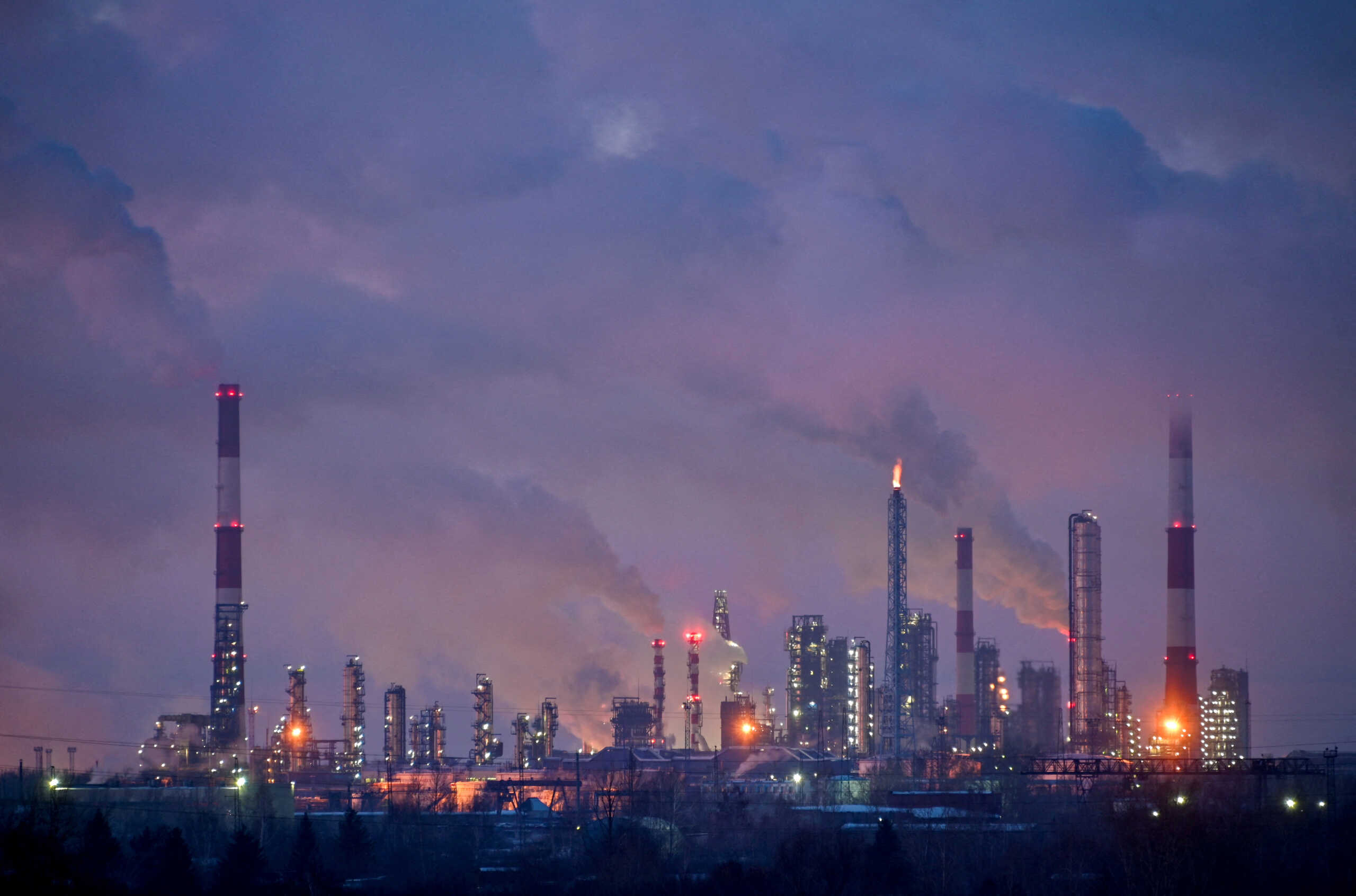 FILE PHOTO: Flue gas and steam rise out of chimneys and smokestacks of an oil refinery during sunset on a frosty day in the Siberian city of Omsk, Russia, February 8, 2023. REUTERS
