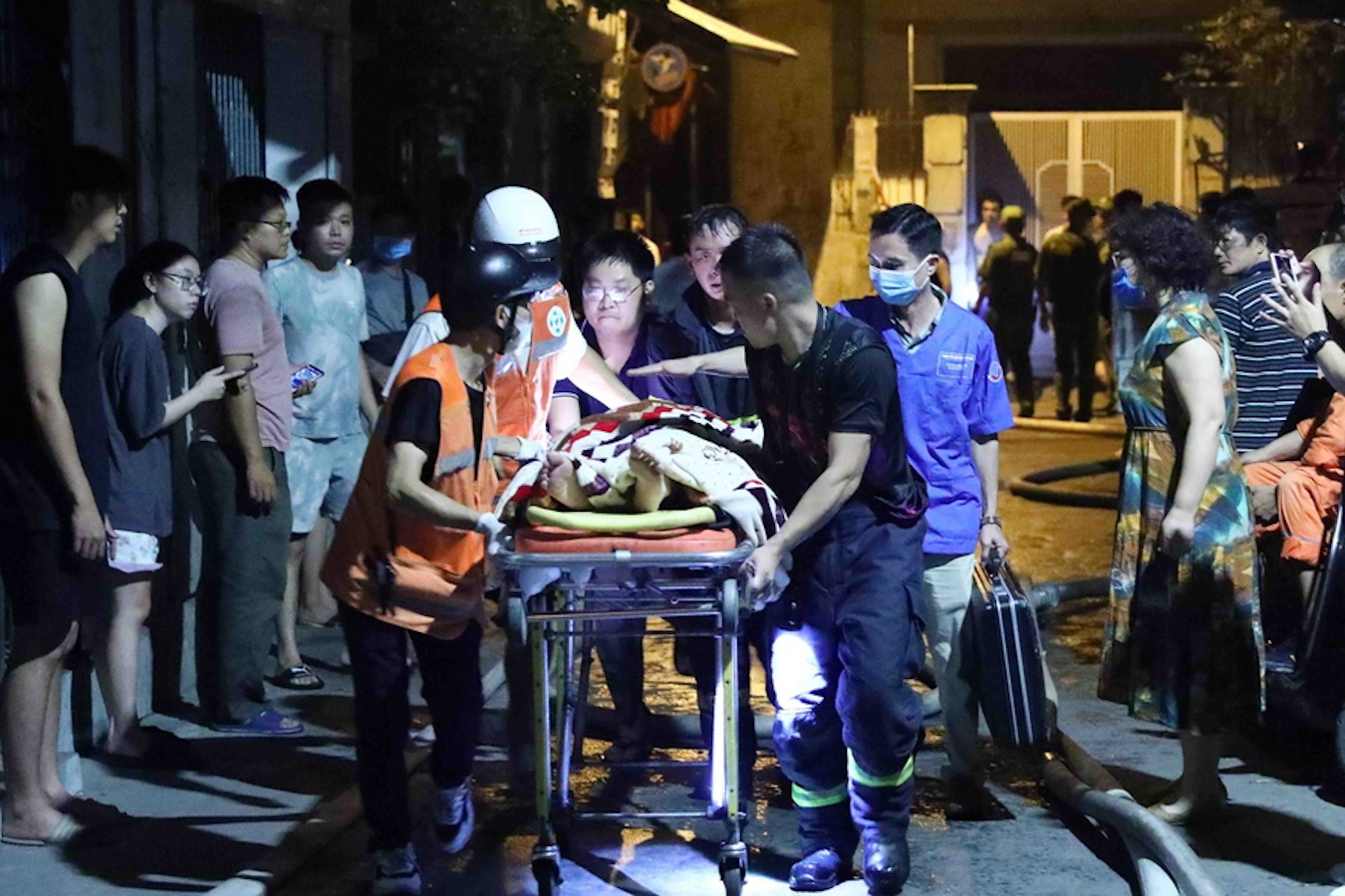 epa10857839 A handout photo made available by Vietnam News Agency (VNA) shows rescue workers carrying victims following a fire at an apartment block in Hanoi, Vietnam, 13 September 2023. The fire started on the first floor of the nine-storey apartment at midnight, and was contained by 2am, according to VNA. Many people were believed dead and several injured, according to the official news agency.  EPA
