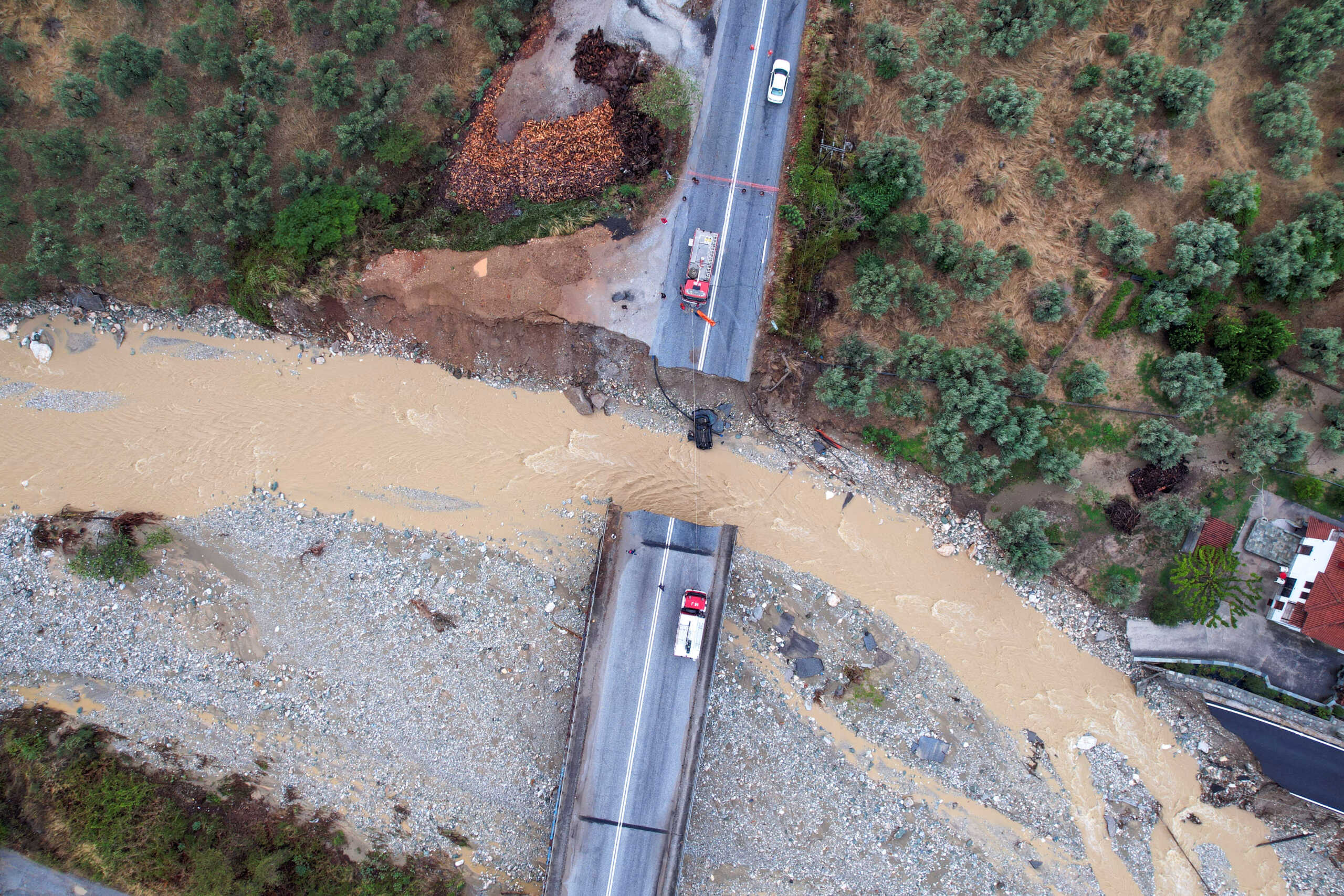 Firefighting crews are seen on a collapsed bridge, as storm Daniel hits central Greece, in the village of Kala Nera, Greece, September 7, 2023. REUTERS