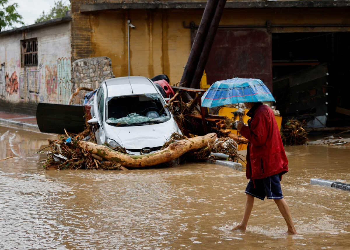 A man holding an umbrella walks on a road flooded due to the impact of storm Daniel, in the city of Volos, Greece, September 6, 2023. REUTERS