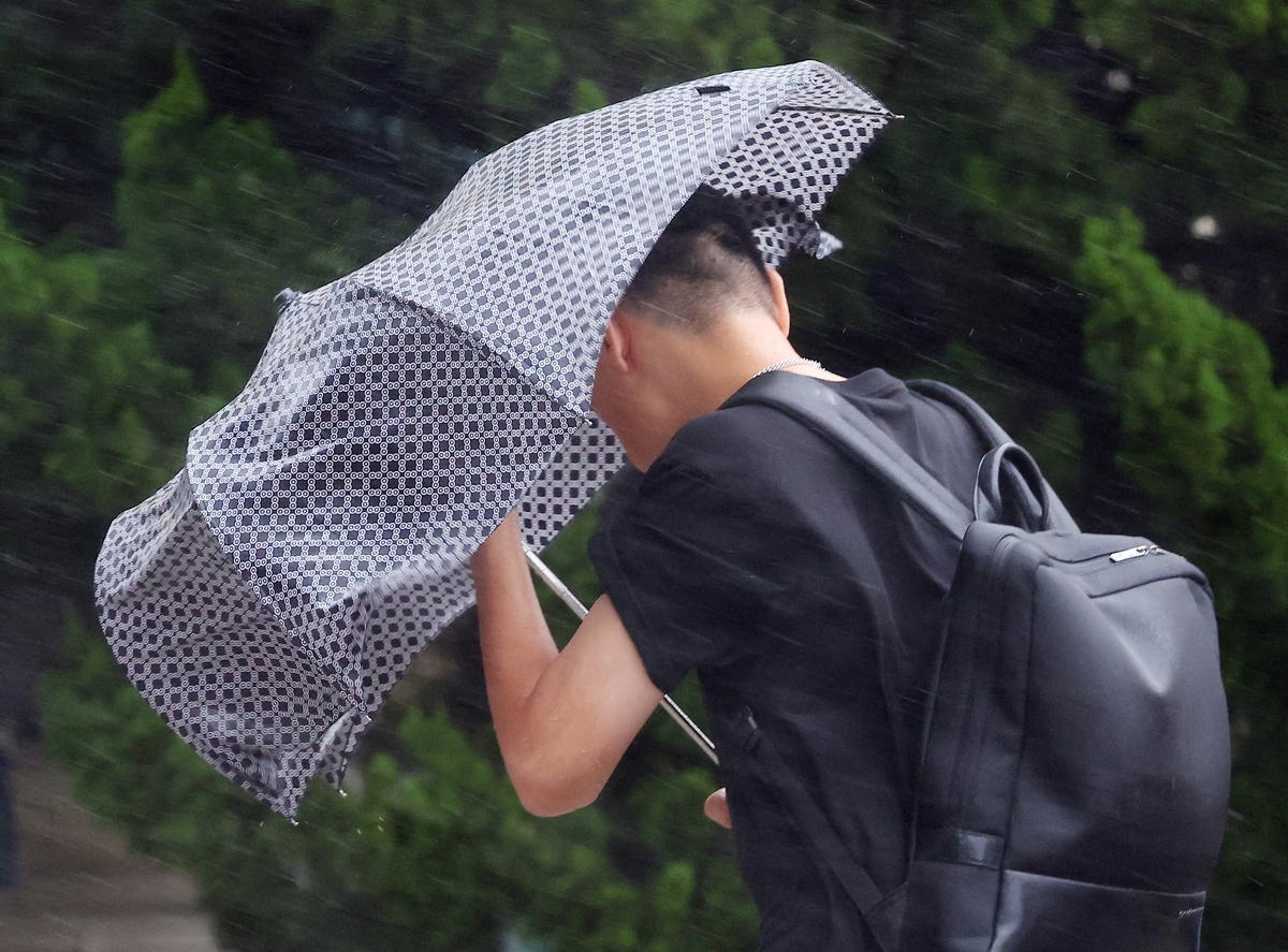 A man makes his way through strong wind caused by typhoon Khanun in Busan, South Korea, August 10, 2023.   Yonhap via REUTERS   THIS IMAGE HAS BEEN SUPPLIED BY A THIRD PARTY. NO RESALES. NO ARCHIVES. SOUTH KOREA OUT. NO COMMERCIAL OR EDITORIAL SALES IN SOUTH KOREA.