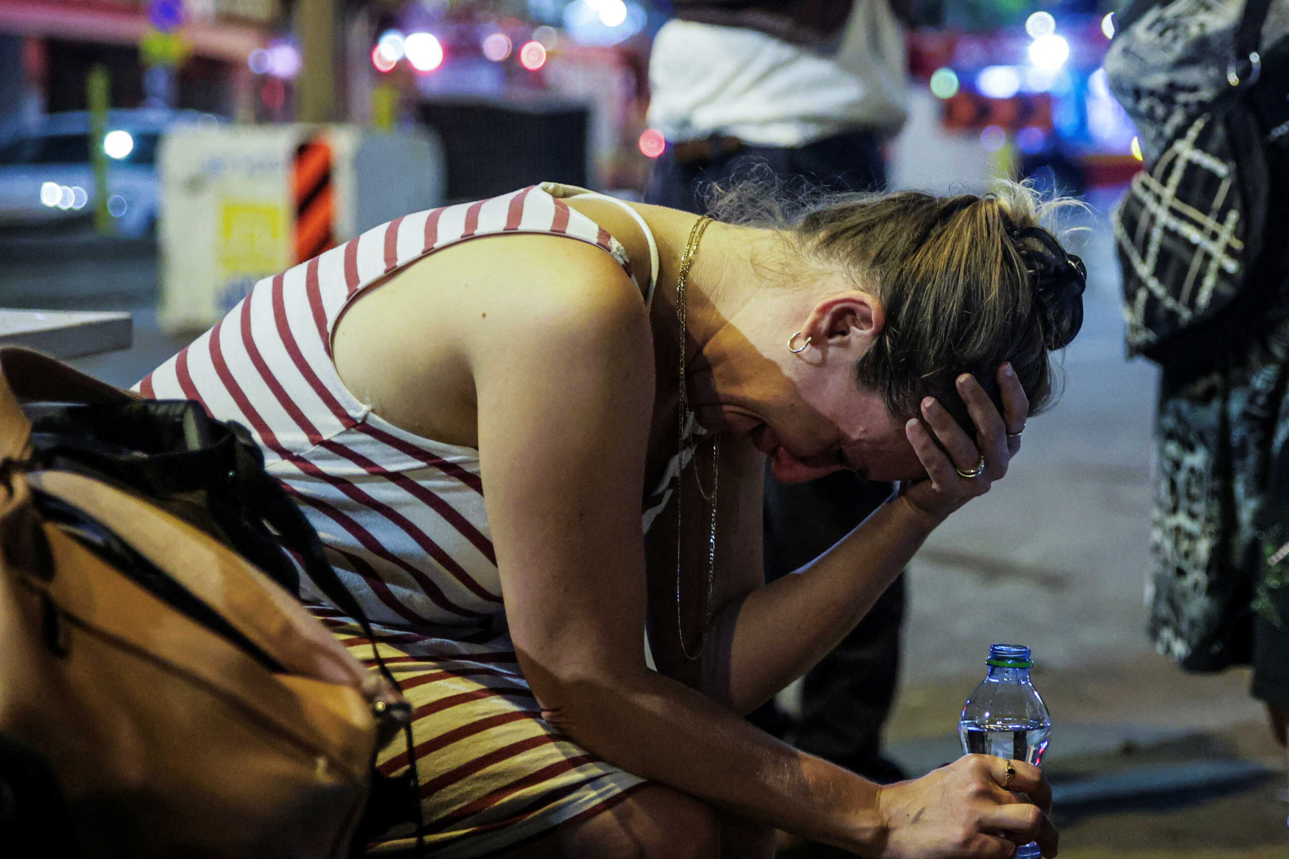 A woman reacts at the site where a rocket launched from the Gaza Strip landed in Tel Aviv, Israel October 7, 2023. REUTERS