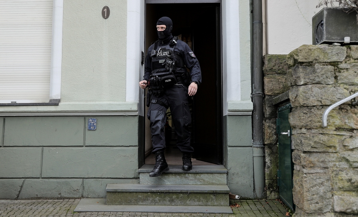 epa10885638 A police officer walks during a raid at the practice and flat of Gerhard H., a doctor and suspected member of the 'Artgemeinschaft' far-right group in Essen, Germany, 27 September 2023. German Interior Minister Nancy Faeser on 27 September announced the ban of the 'deeply racist and antisemitic right-wing extremist' association, including all its sub-organizations. Police forces have been searching 26 apartments of 39 suspected members and the group's premises in twelve federal states.  EPA