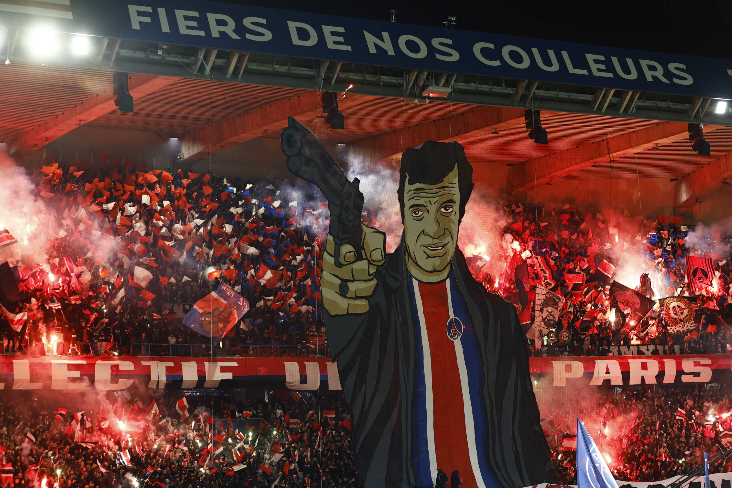 Soccer Football - Champions League - Group F - Paris St Germain v AC Milan - Parc des Princes, Paris, France - October 25, 2023 Paris St Germain fans display a tifo depicting actor Jean-Paul Belmondo as they let off flares inside the stadium before the match REUTERS