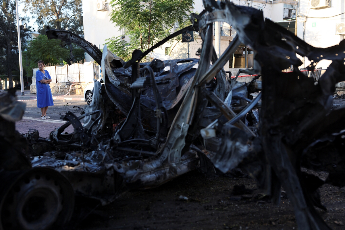 A woman looks on at a damaged site following a rocket attack the night before, from the Gaza Strip that landed in Ashkelon, southern Israel October 21, 2023. REUTERS