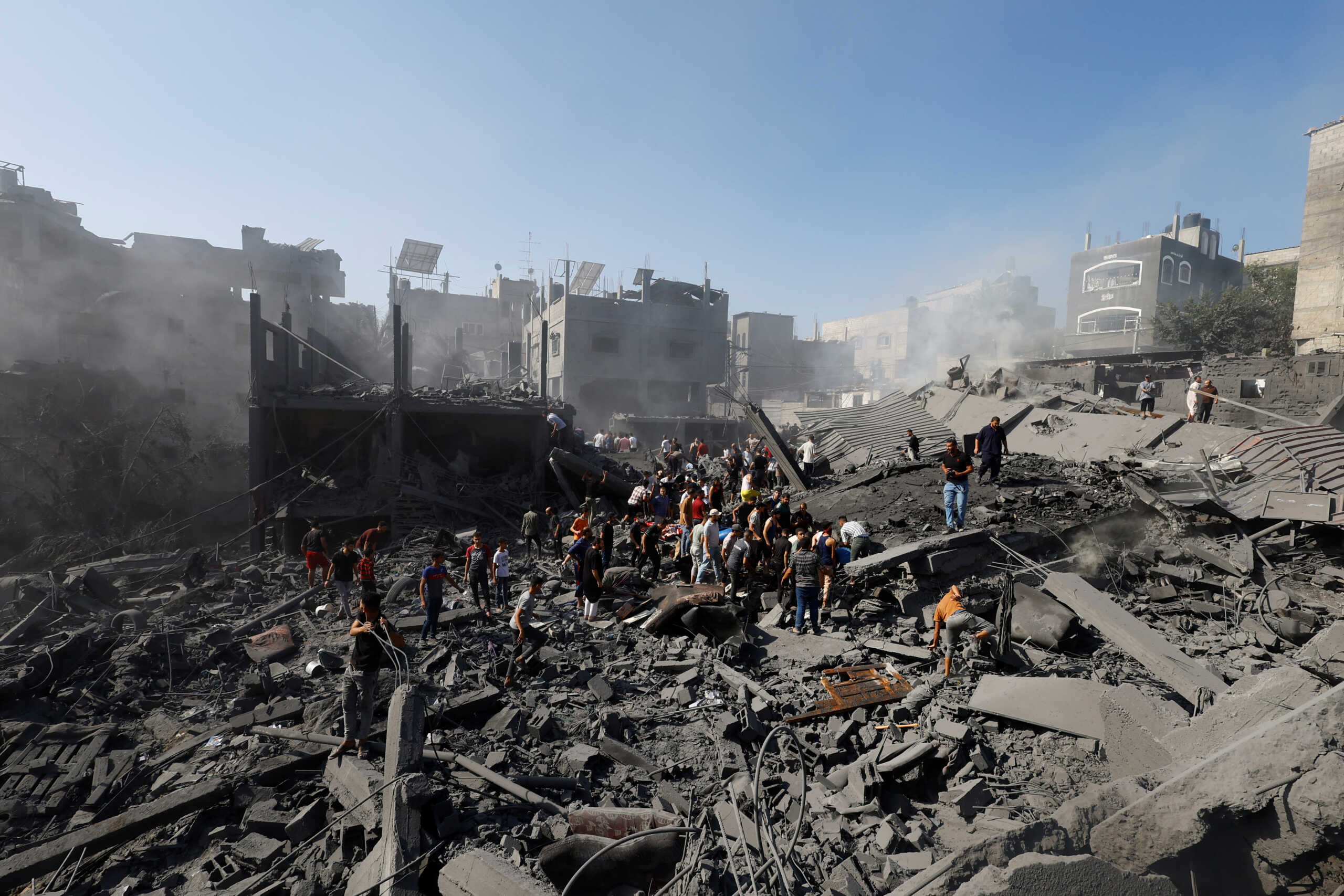 Palestinians gather at the site of Israeli strikes on houses, as the conflict between Israel and Palestinian Islamist group Hamas continues, in Khan Younis in the southern Gaza Strip, October 26, 2023. REUTERS