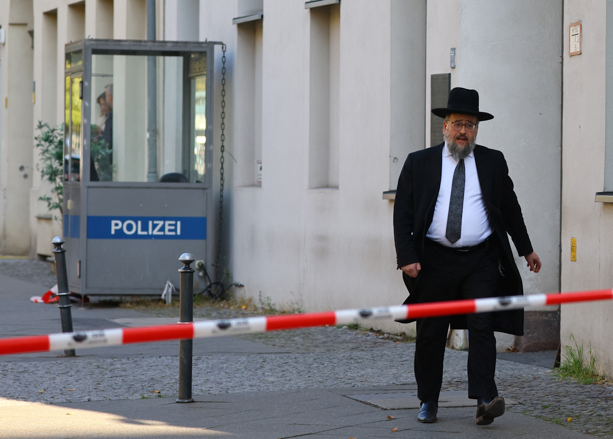 A member of the Jewish community walks behind barrier tape following a police lockdown of the area after two Molotov cocktails were thrown at the Skoblo Synagogue and Education Center overnight in Berlin, Germany, October 18, 2023. REUTERS