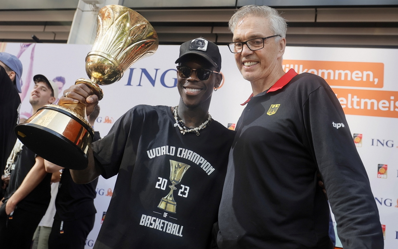 epa10855810 German national Basketball head coach Gordon Herbert and Dennis Schroeder (L) cheers with the trophy  during a reception in Frankfurt am Main, Germany, 12 September 2023. The Basketball national team won on 10 September 2023 for the first time the World Championships.  EPA